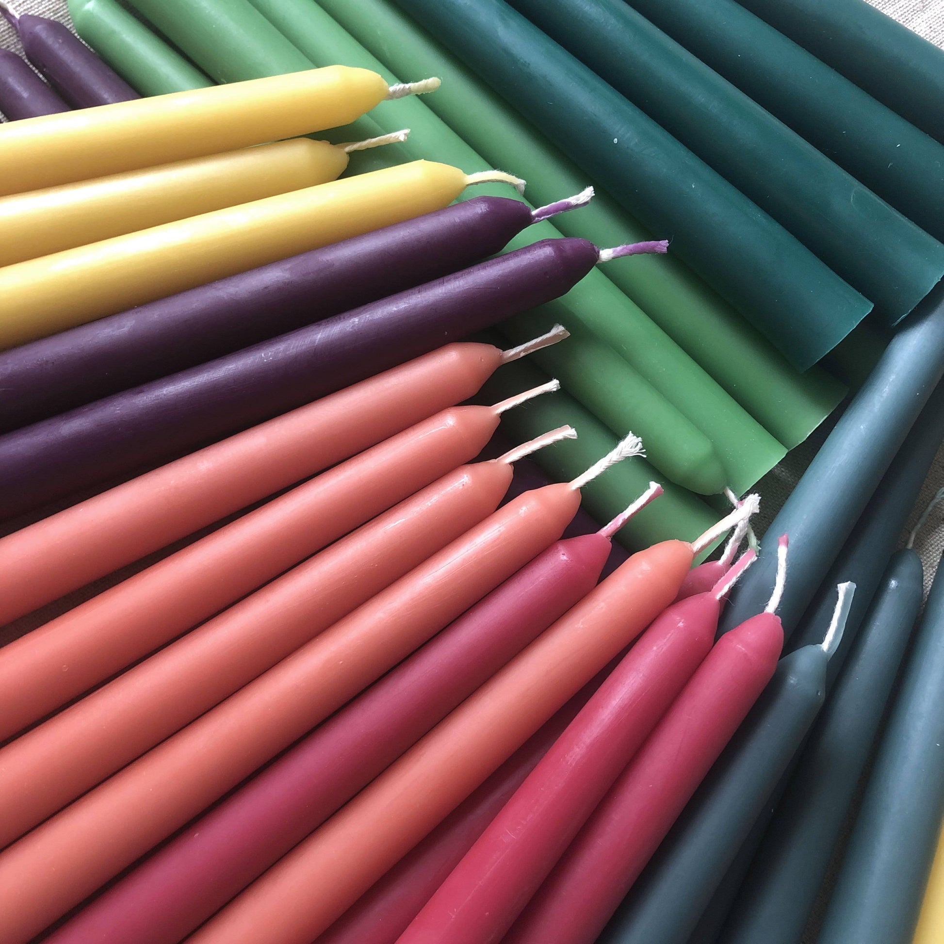 Colorful candles in various shades including purple, green, yellow, and pink.