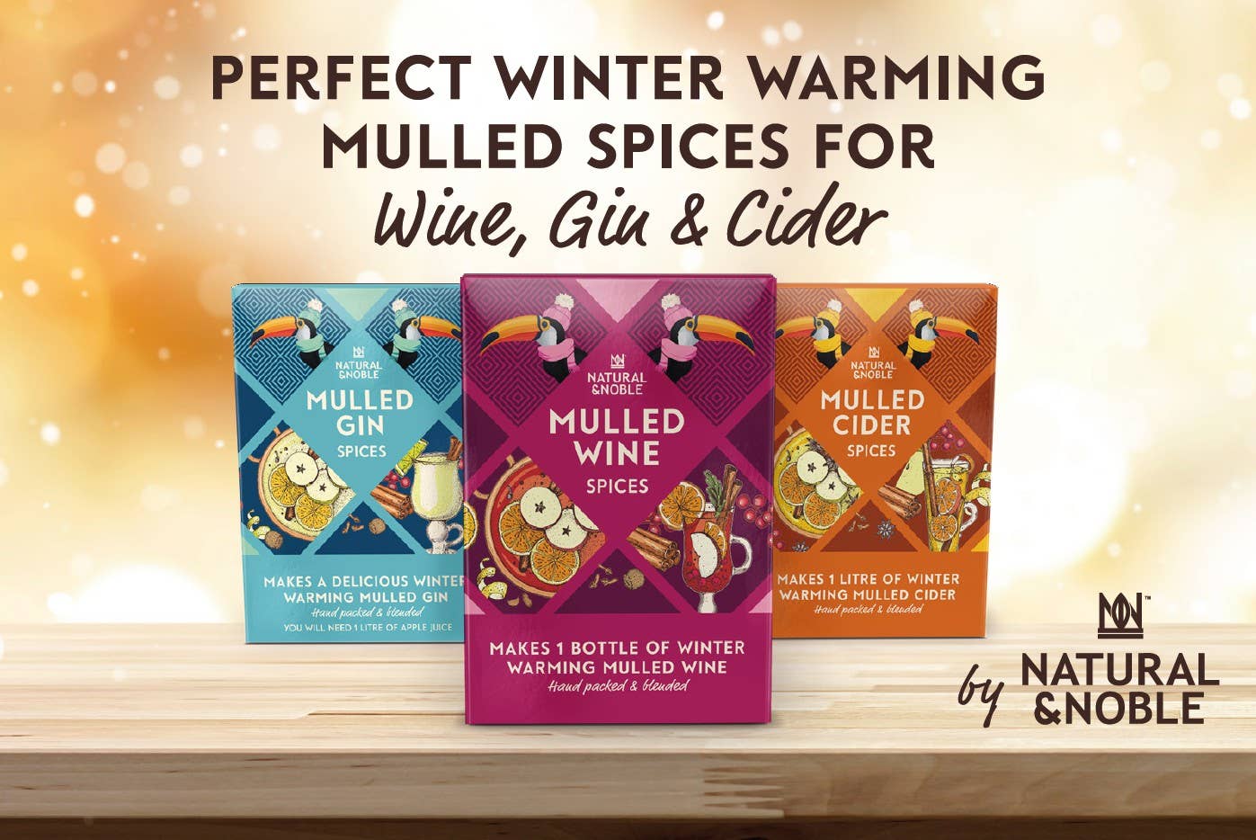 Three boxes of mulled spices for wine, gin, and cider with a warm glow background. Natural & Noble branding visible.