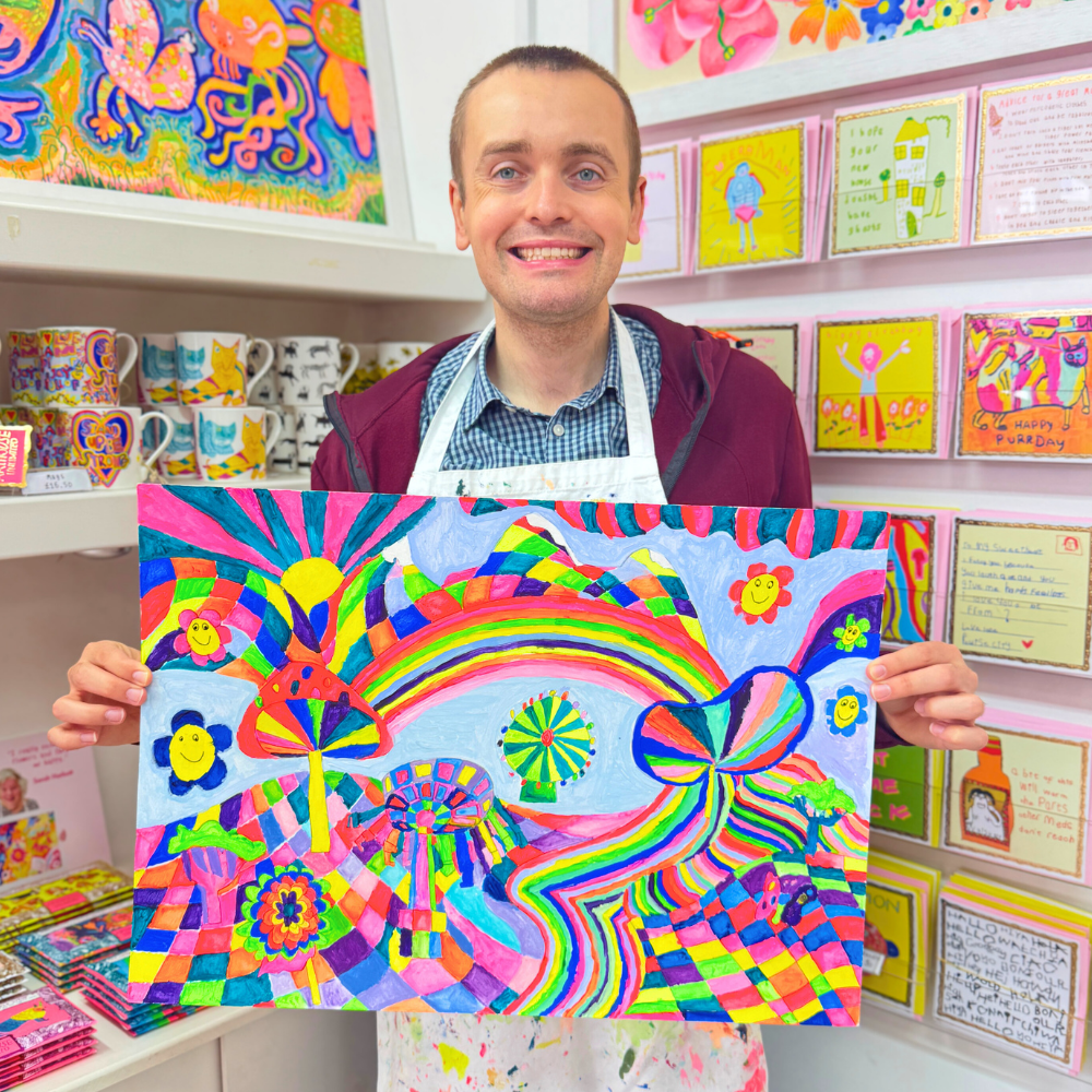 Man holding a colorful abstract painting in a store setting