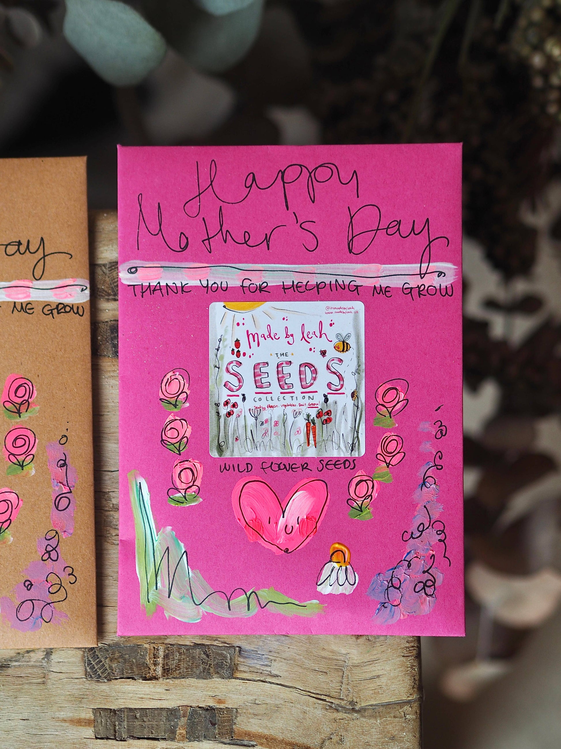 Pink Mother's Day card with 'Happy Mother's Day' text and plant seed packaging.