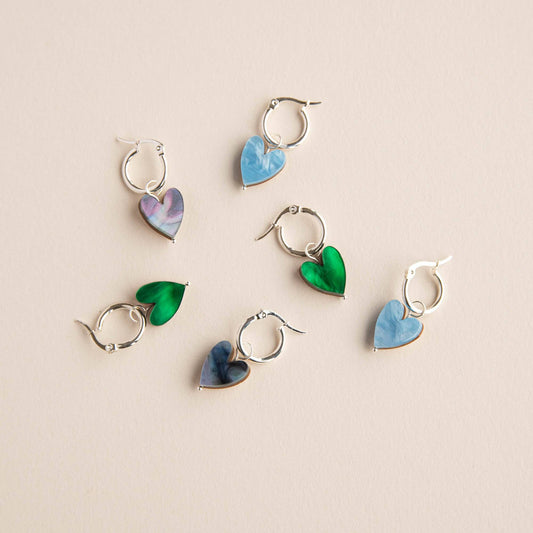 Set of heart-shaped earrings on a beige background