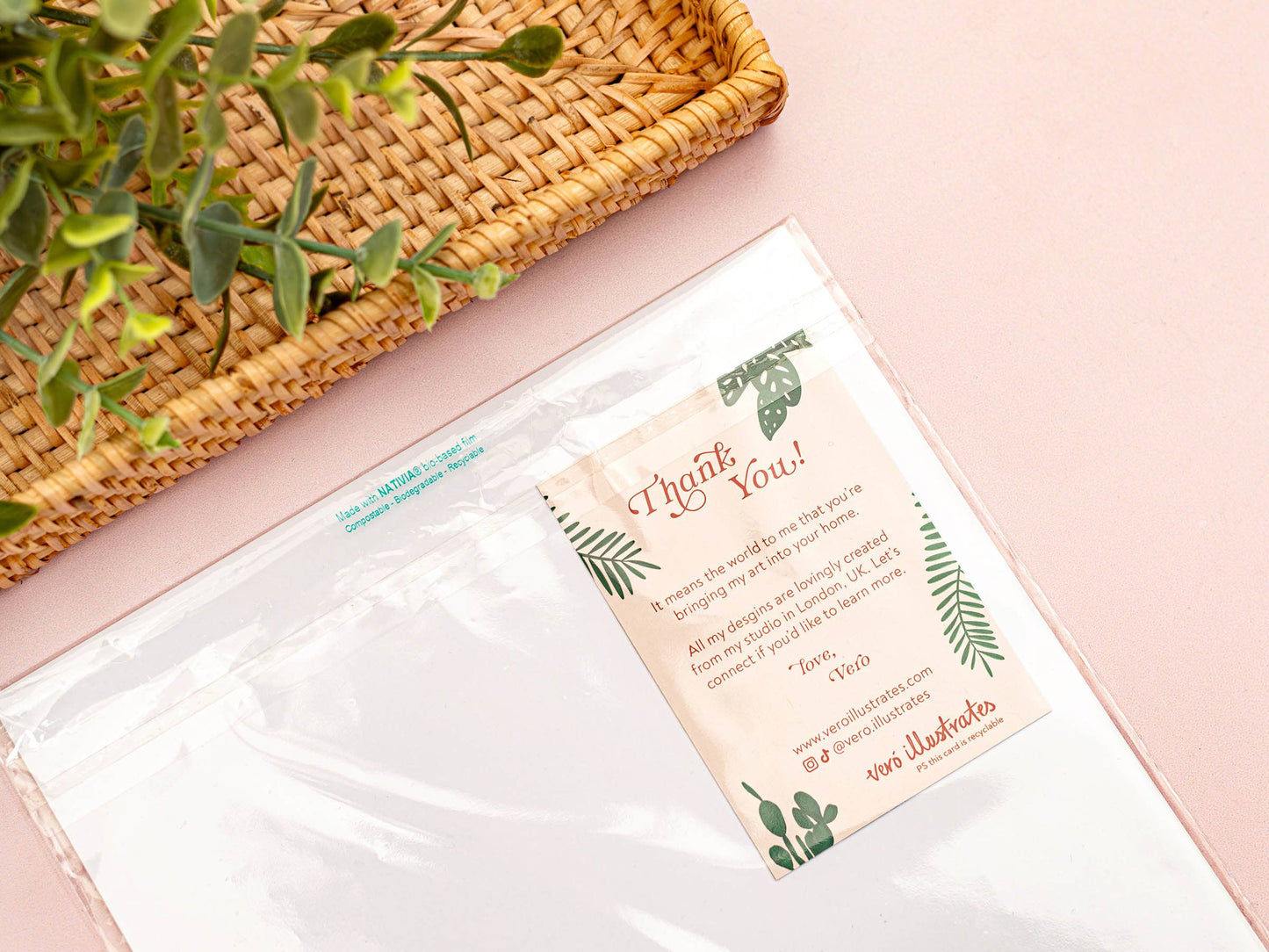 Thank you card with green leaf illustrations on a pink surface with a woven basket and plant.