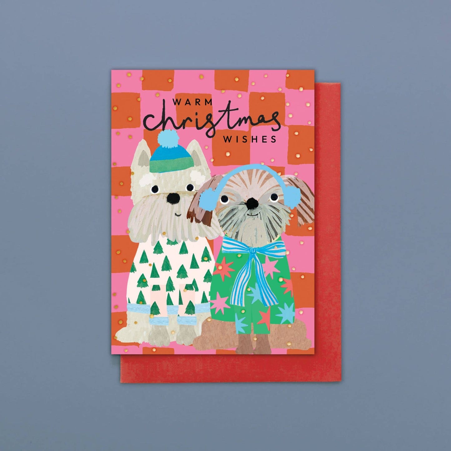 Christmas card with two dogs wearing winter clothing on a pink and orange checkered background.