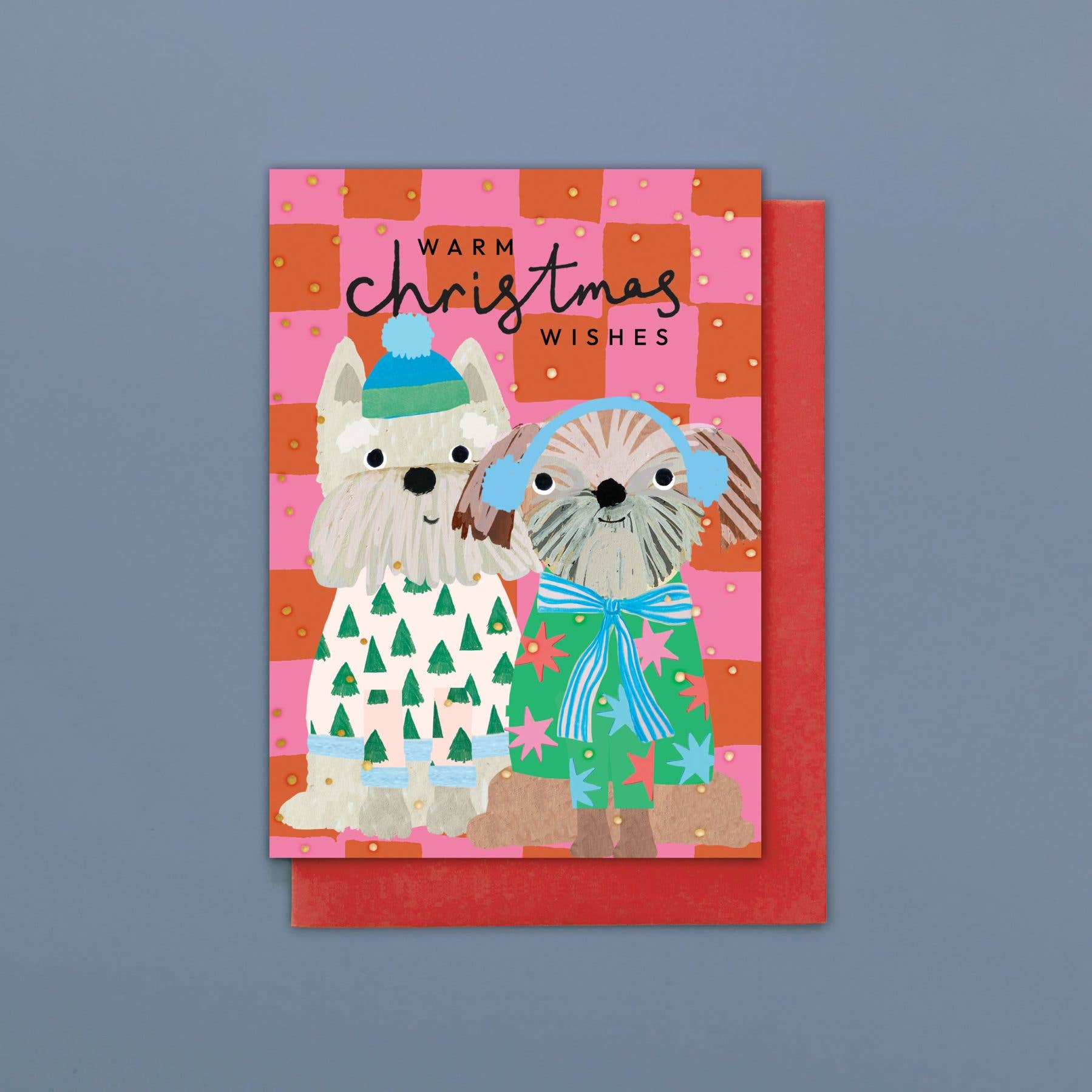 Christmas card with two dogs wearing winter clothing on a pink and orange checkered background.