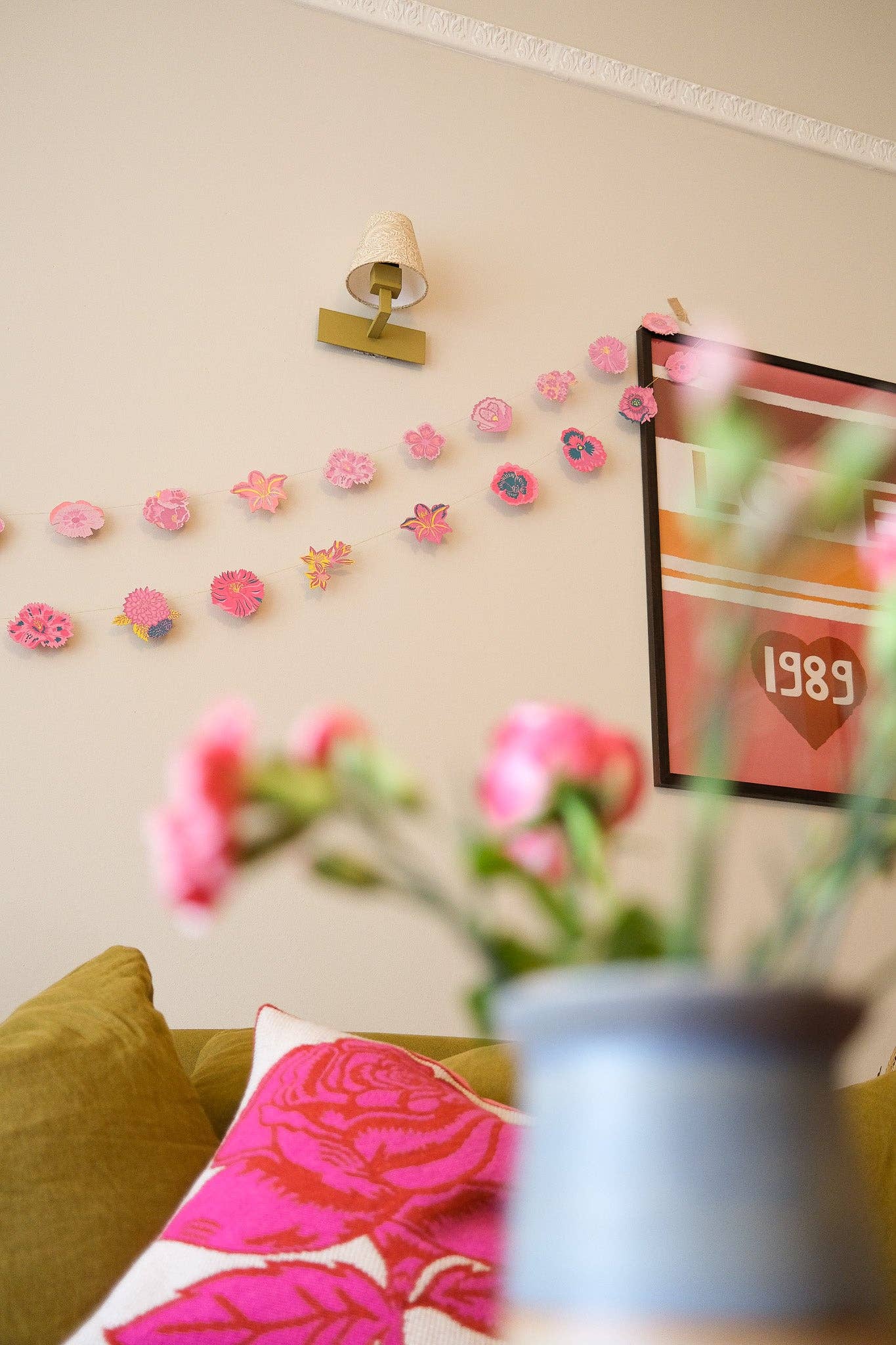 Decorative wall stickers on a beige wall with a couch and floral arrangement in the foreground.