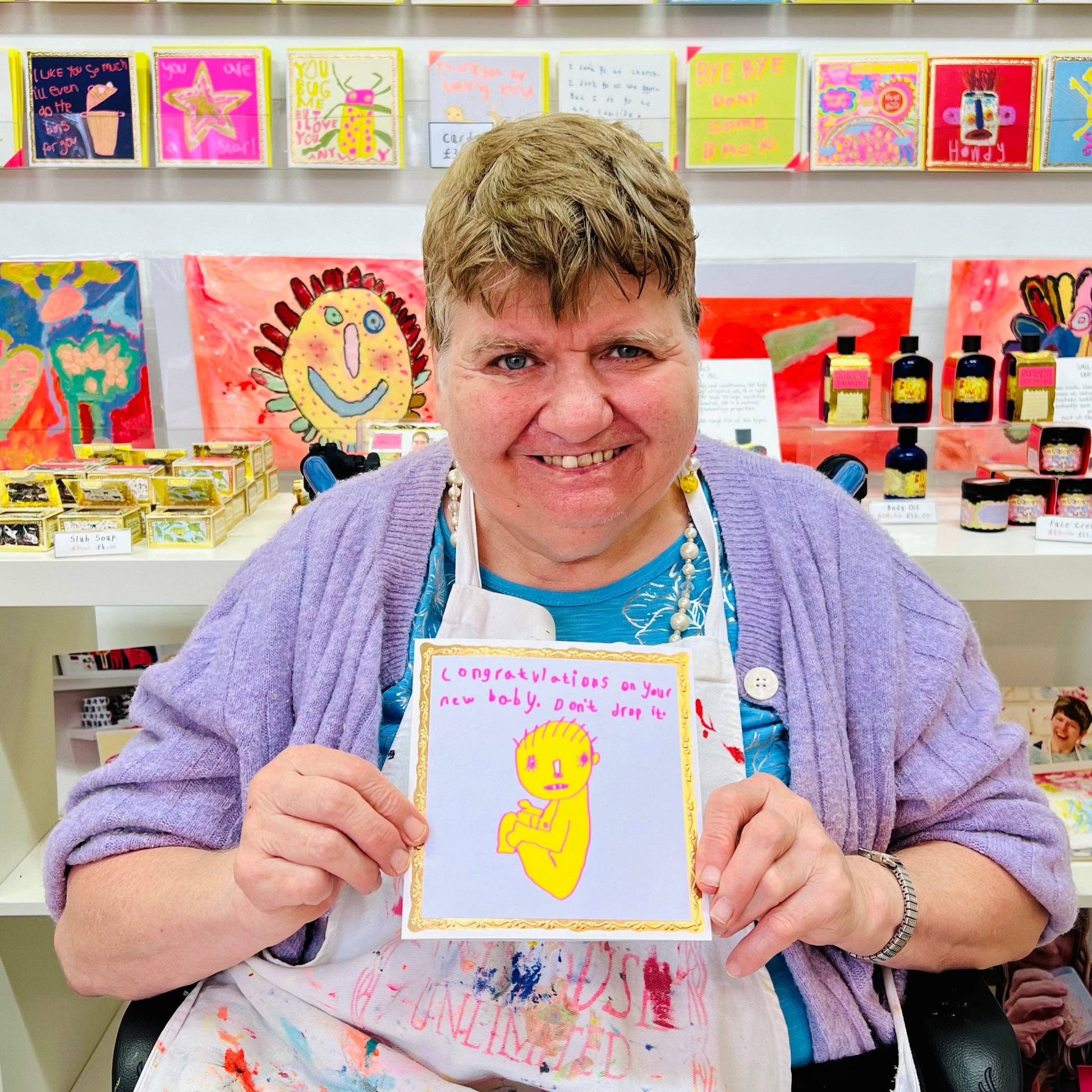Person holding a card with a yellow creature design in a craft store setting