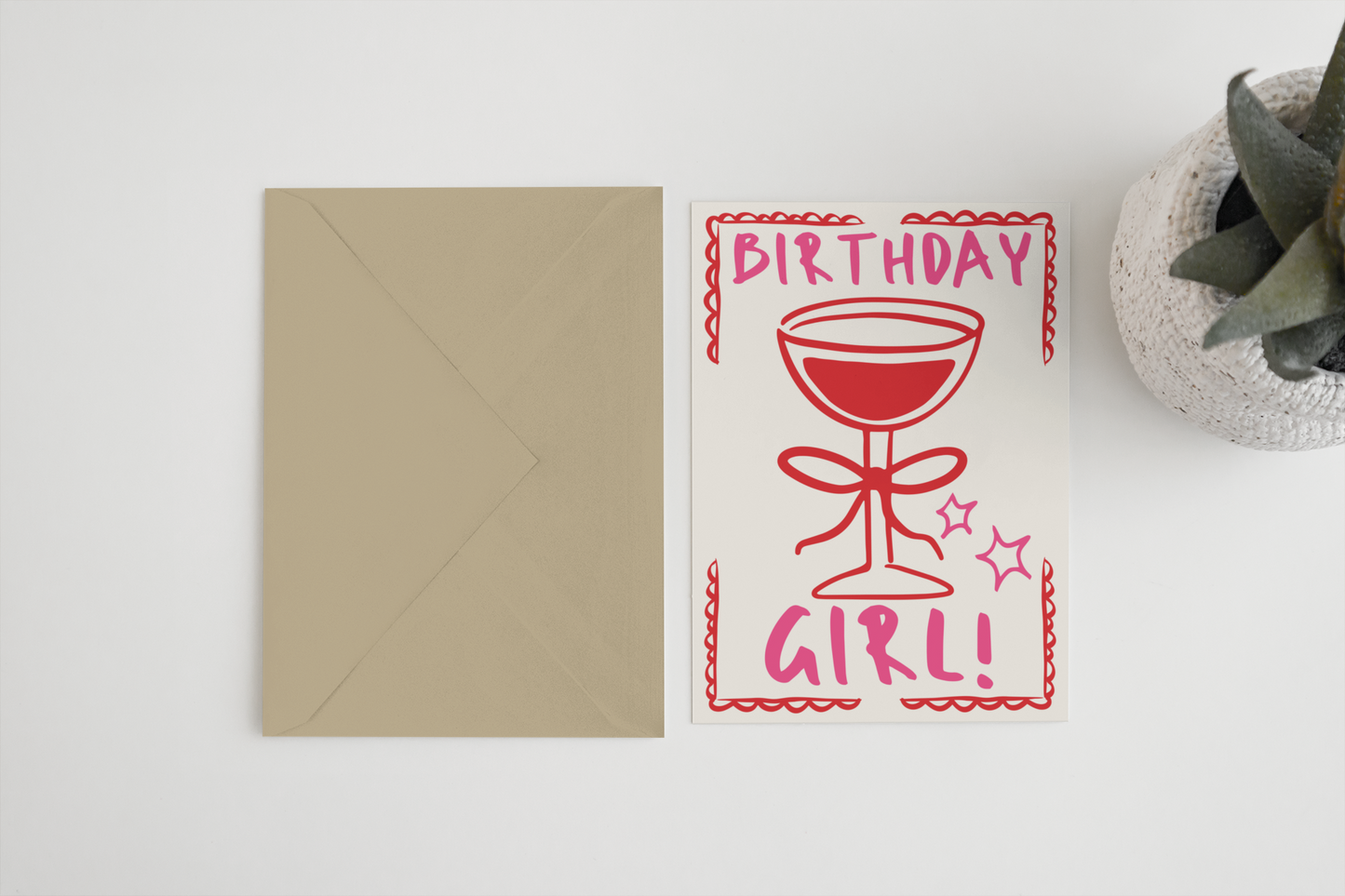 Birthday card with red text and envelope on a white surface