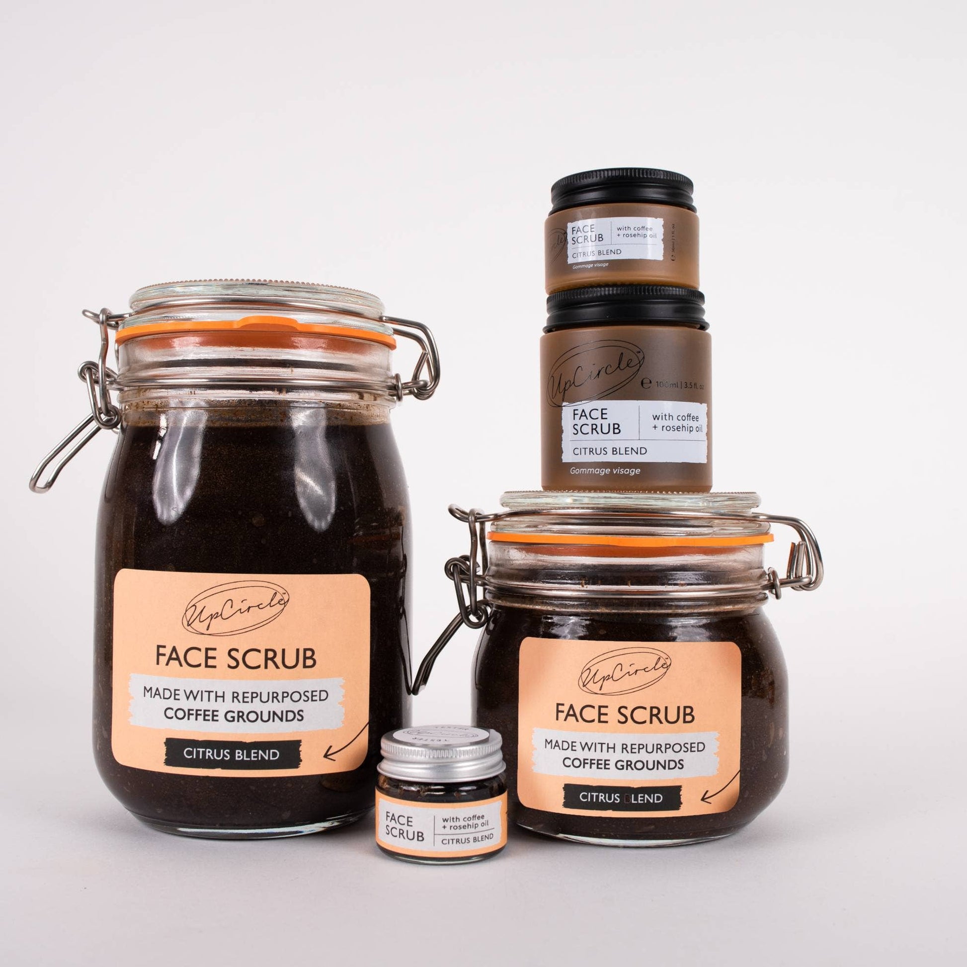 A series of jars containing a citrus-blend face scrub with coffee and rosehip oil.
