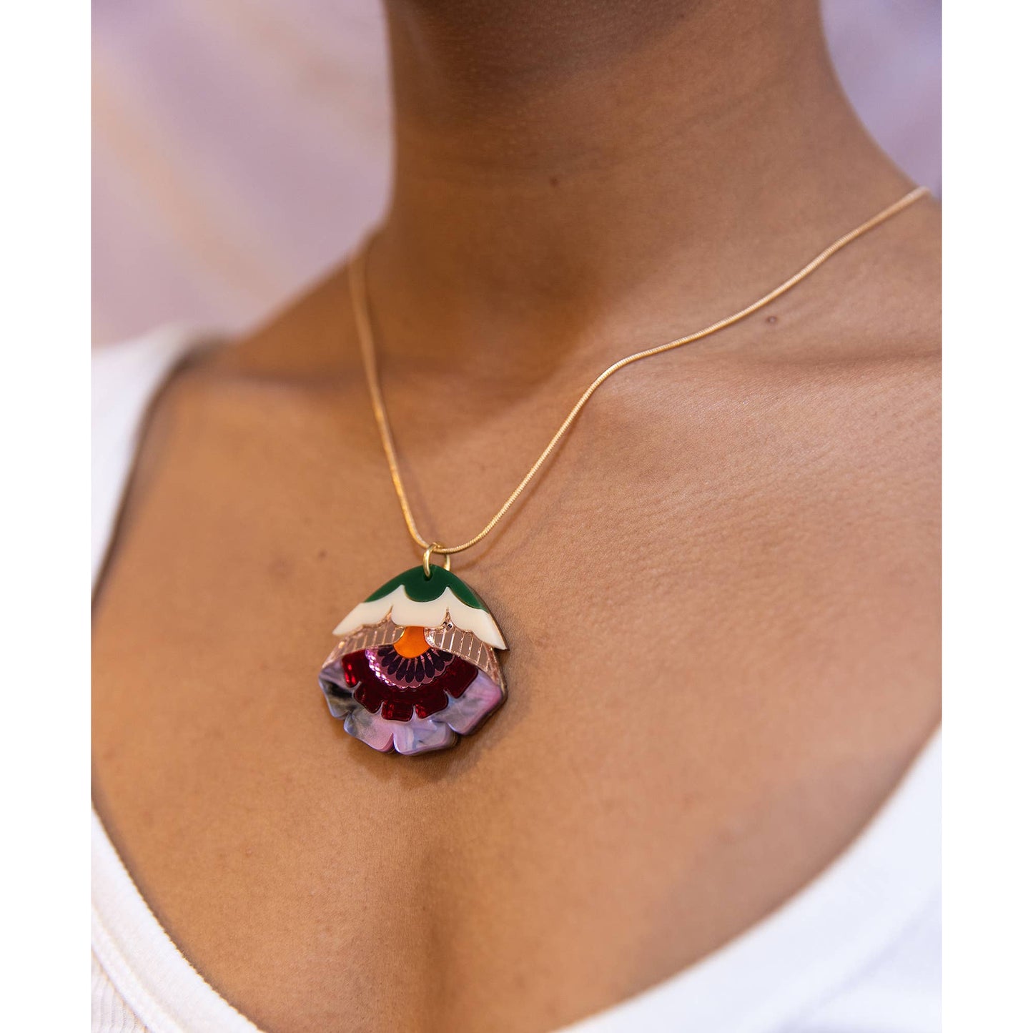 Necklace with a colorful pendant worn by a person