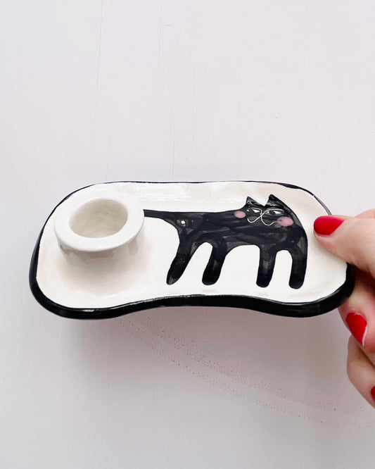 Ceramic comb-shaped tray with a hand holding it on a white background