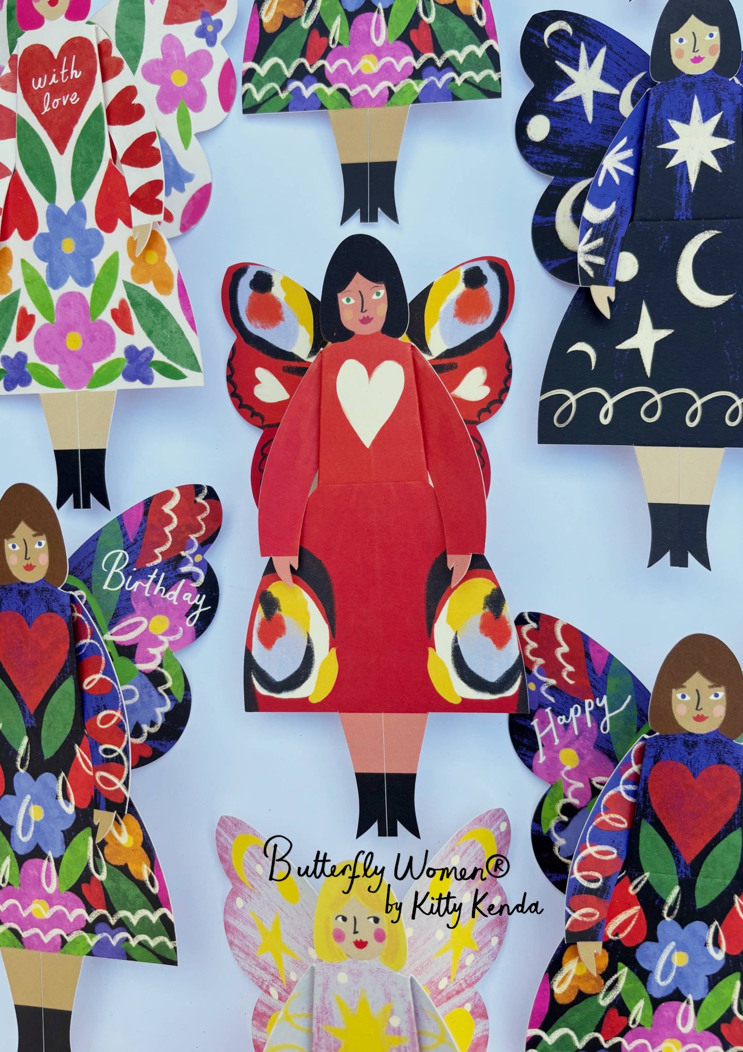 Colorful paper dolls with butterfly wings on a light blue background, featuring the brand 'Butterfly Women by Kitty Kenda'.