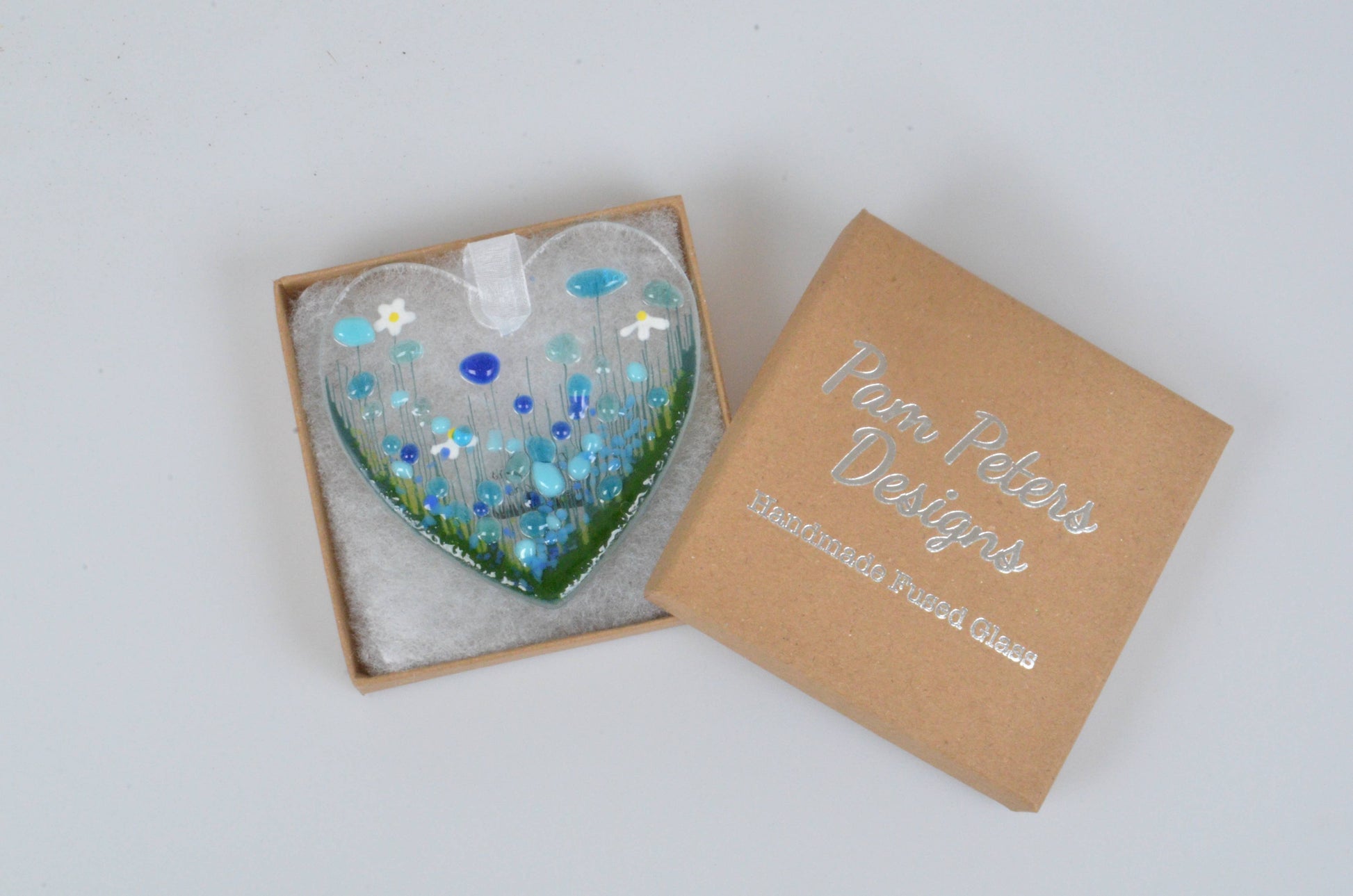 Heart-shaped decorative item with mosaic design in a box labeled 'Pamela Pothier Designs'.