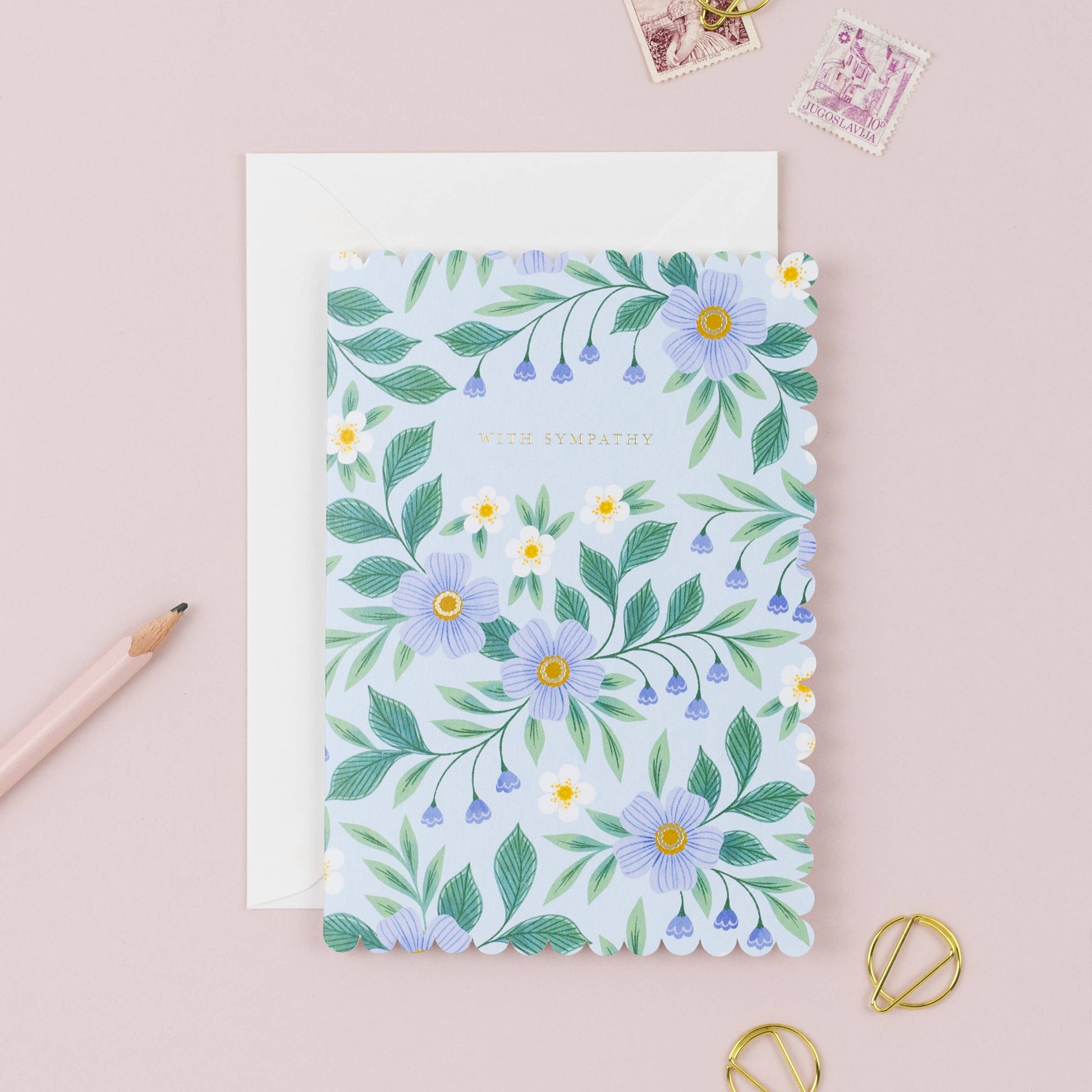 Floral card on a pink background with stationery items