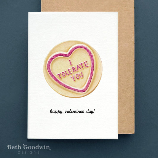 Valentine's Day card with a heart-shaped cookie and 'I Tolerate You' text on a white background.