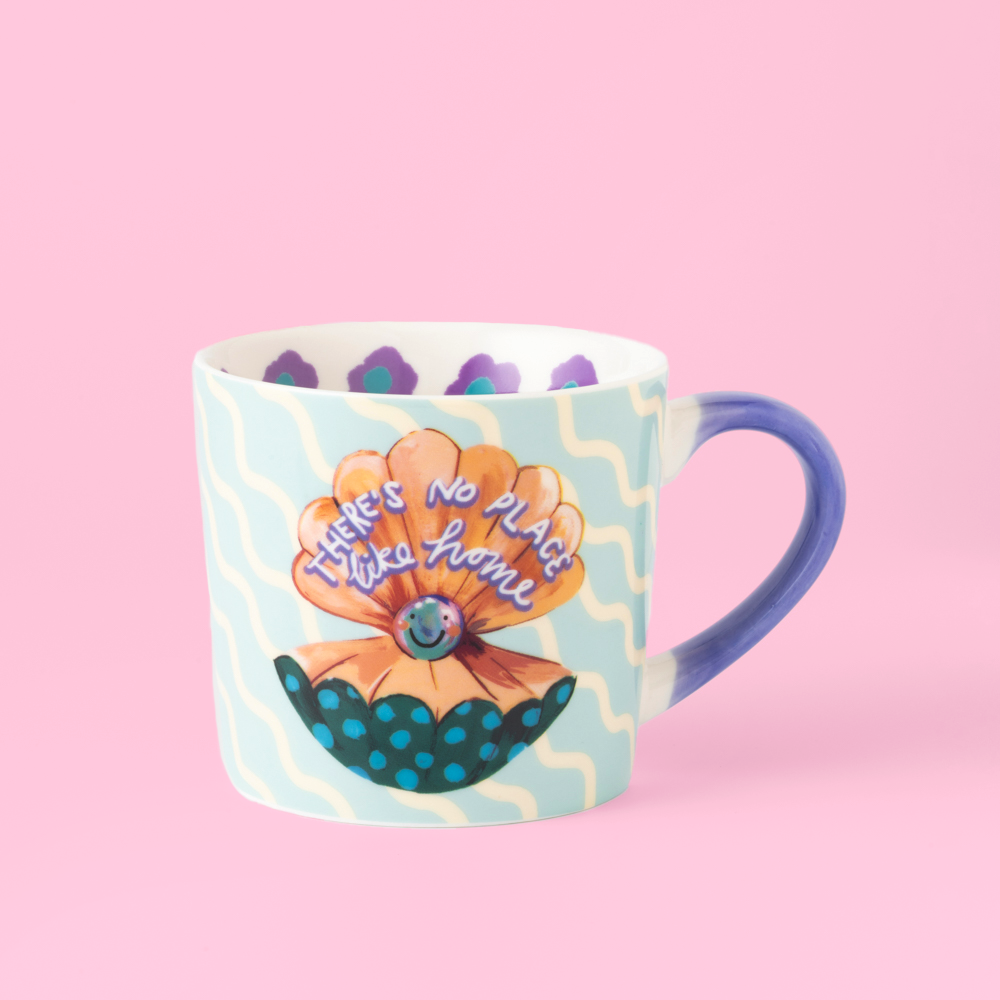 Mug with a colorful design featuring an orange flower and text on a pink background