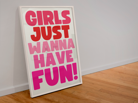 Framed poster with 'Girls Just Wanna Have Fun!' text on a white wall.