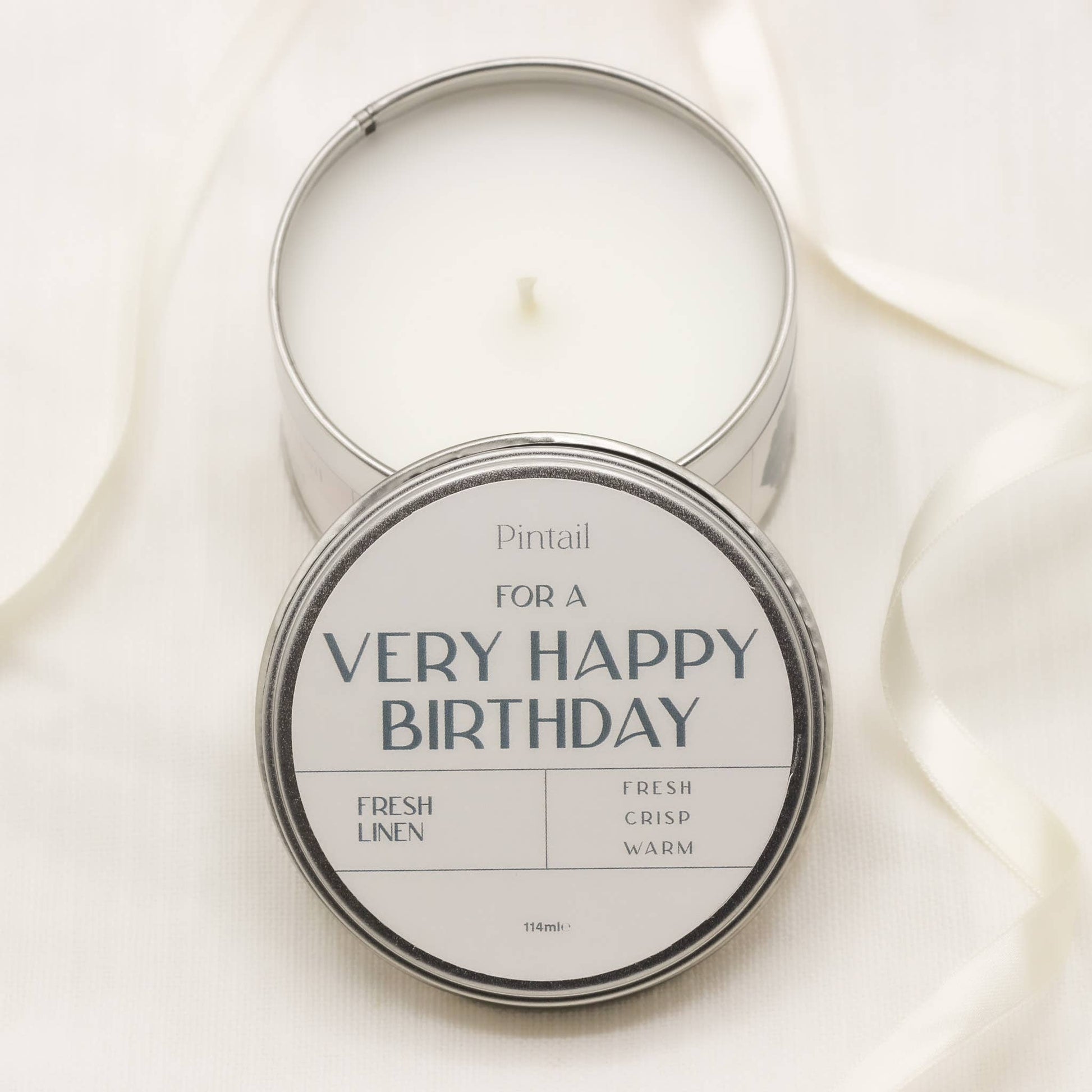 Candle in a tin with 'For a Very Happy Birthday' text on a light background