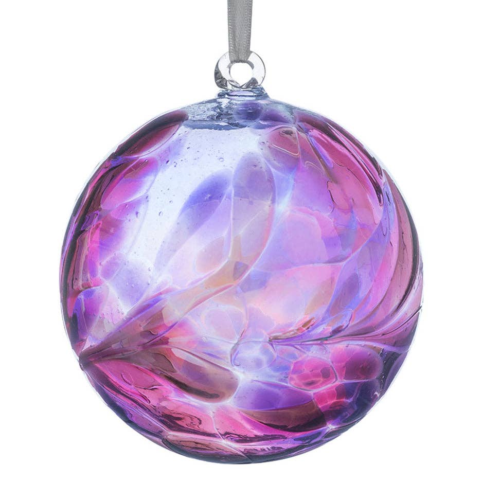 Colorful glass ornament with a swirling pattern on a white background
