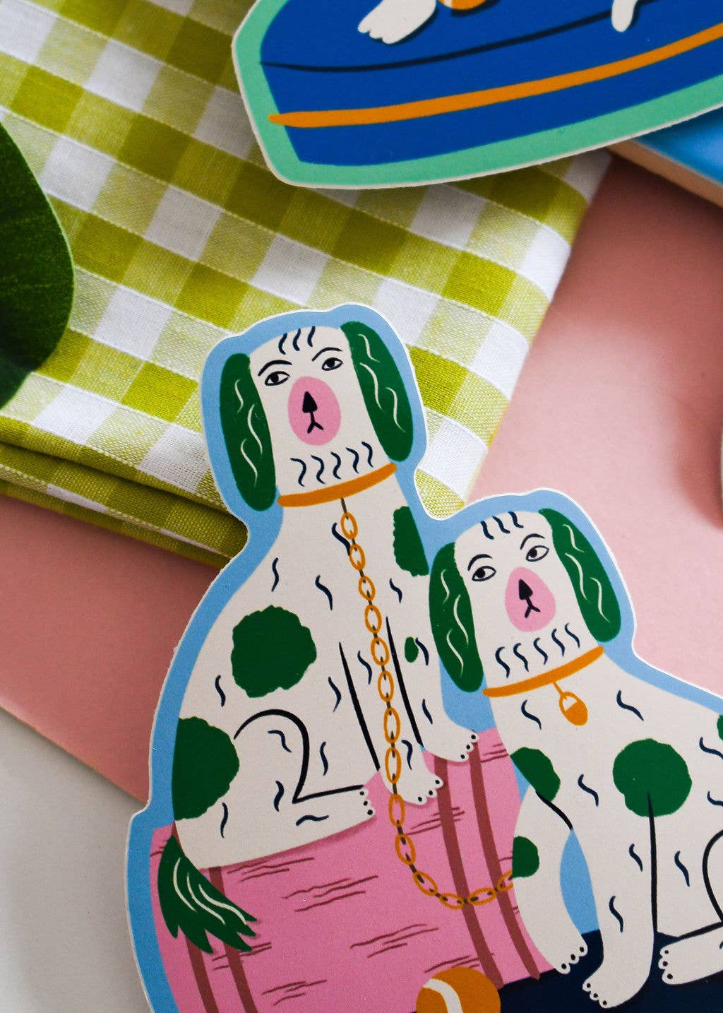 Two decorative dog-shaped stickers on a checkered cloth background