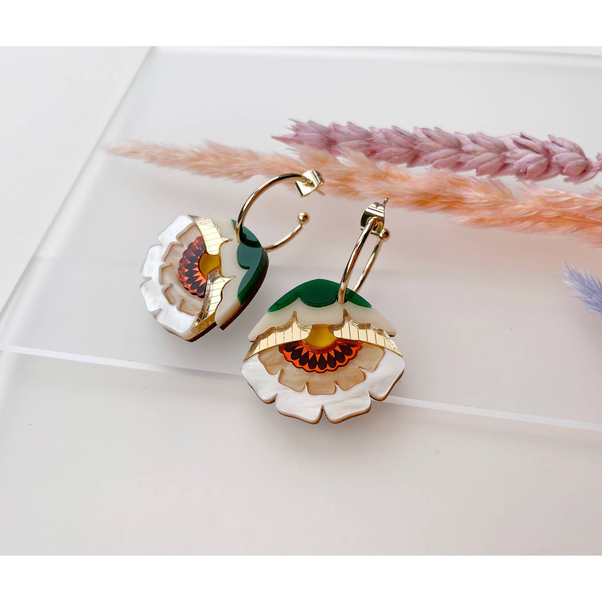 Floral earrings with gold accents on a light background