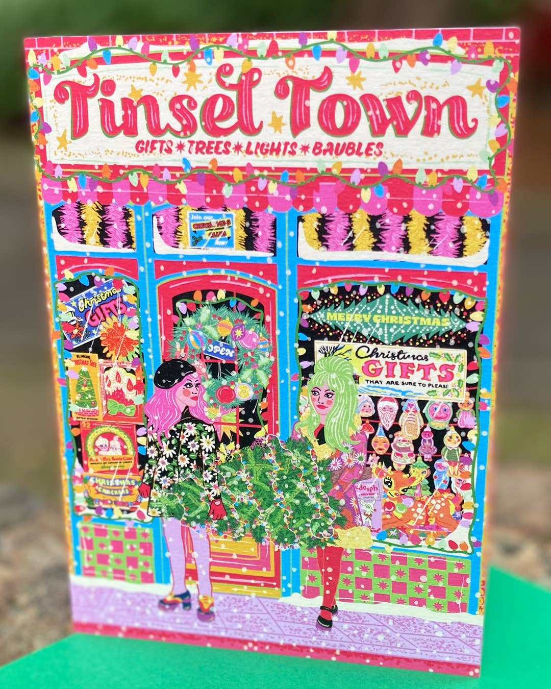 Colorful packaging for 'Tinsel Town' Christmas decorations with a festive scene.