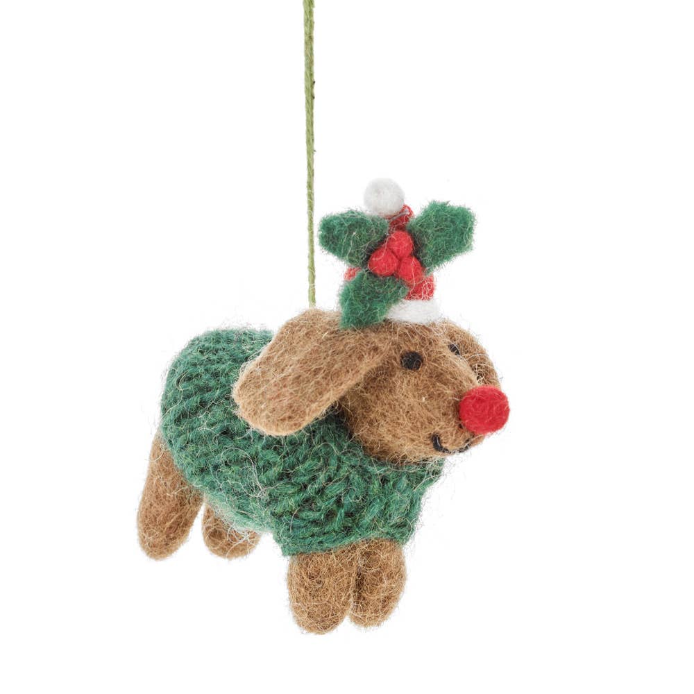 Felted dog ornament wearing a green sweater with a holly leaf and berry on a white background