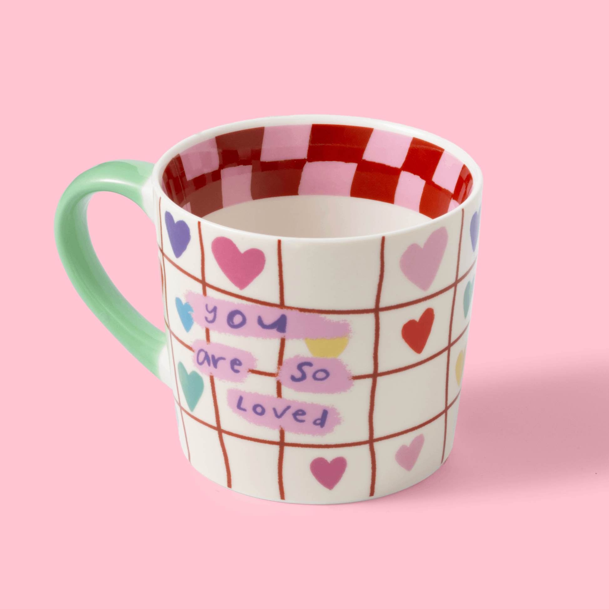 Mug with heart patterns and text on a pink background