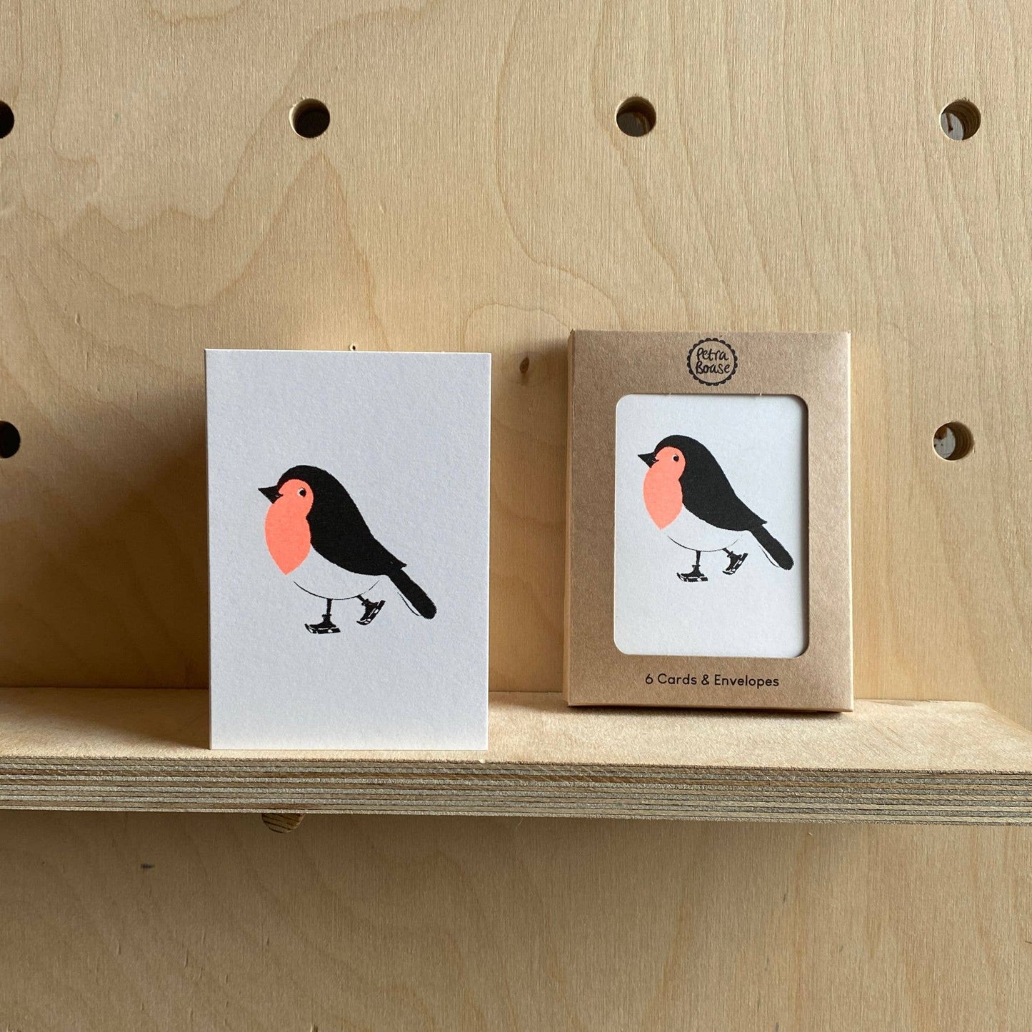 Card with a bird illustration on a wooden shelf