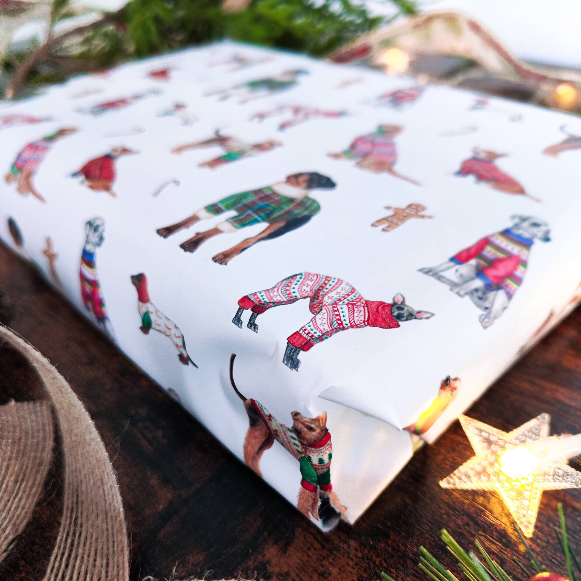 Gift wrap with festive animal illustrations on a wooden surface with a star decoration.
