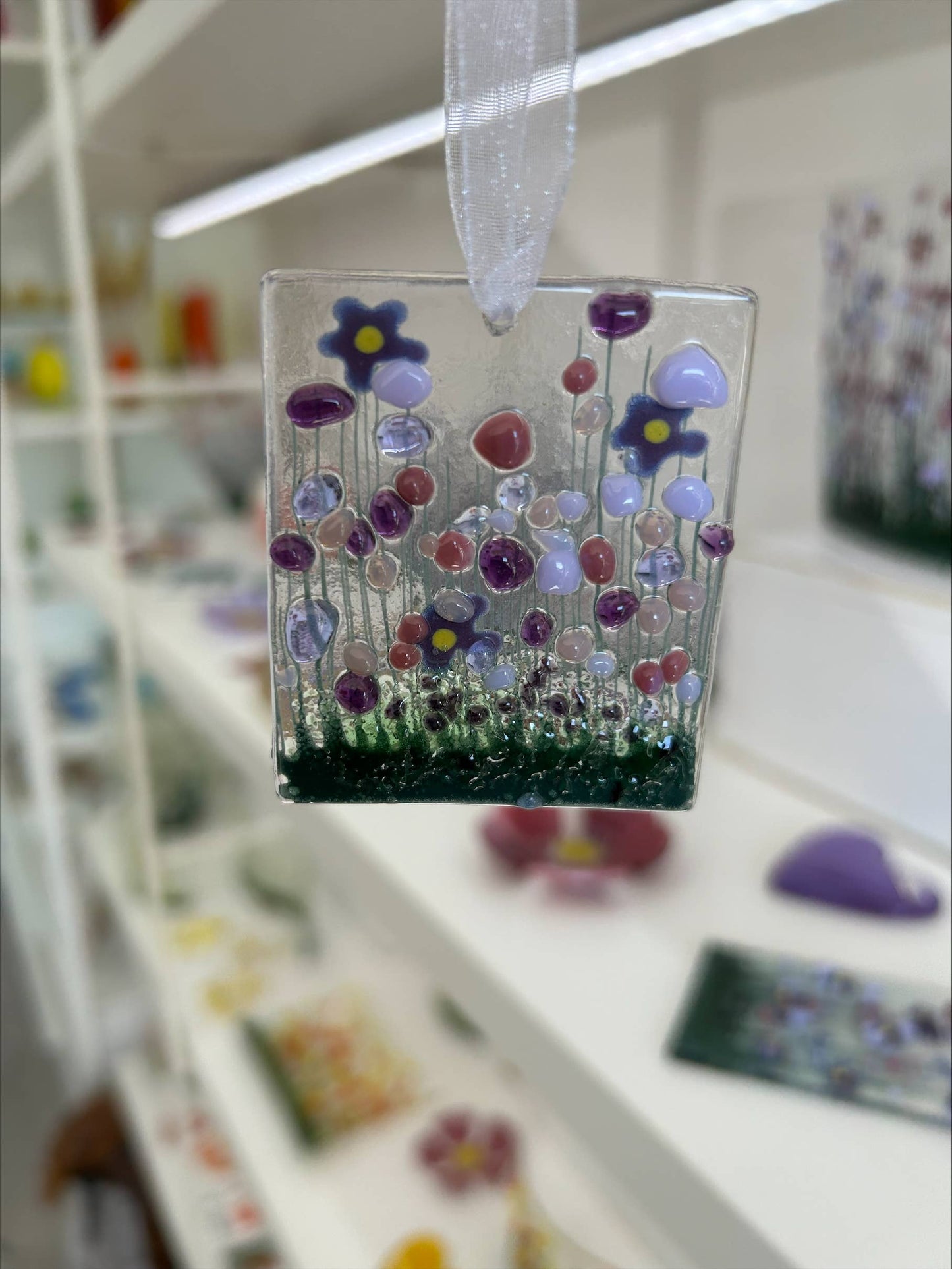 Decorative glass panel with colorful flowers on a blurred background