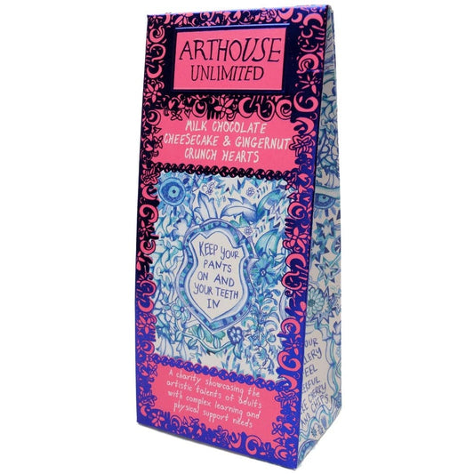 A boxed snack product standing upright on a plain white background. The package is branded Arthouse Unlimited and features a decorative multicolor design with pink, blue, purple, and white ornamental patterns and readable flavor text: milk chocolate cheesecake & gingernut crunch hearts.