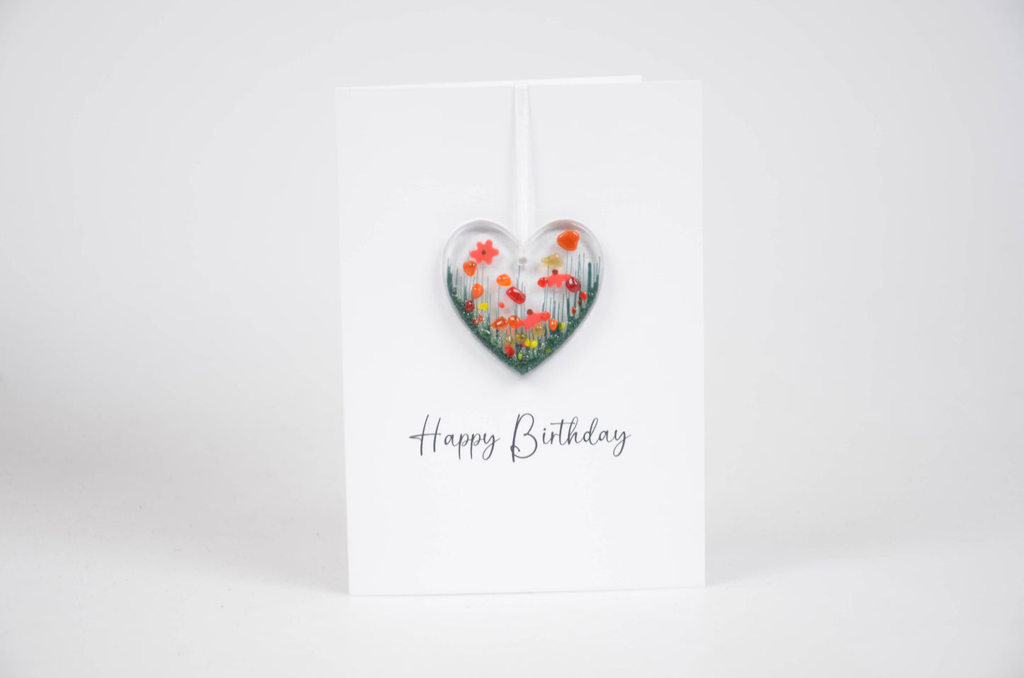 Heart-shaped floral decoration with 'Happy Birthday' text on a white background