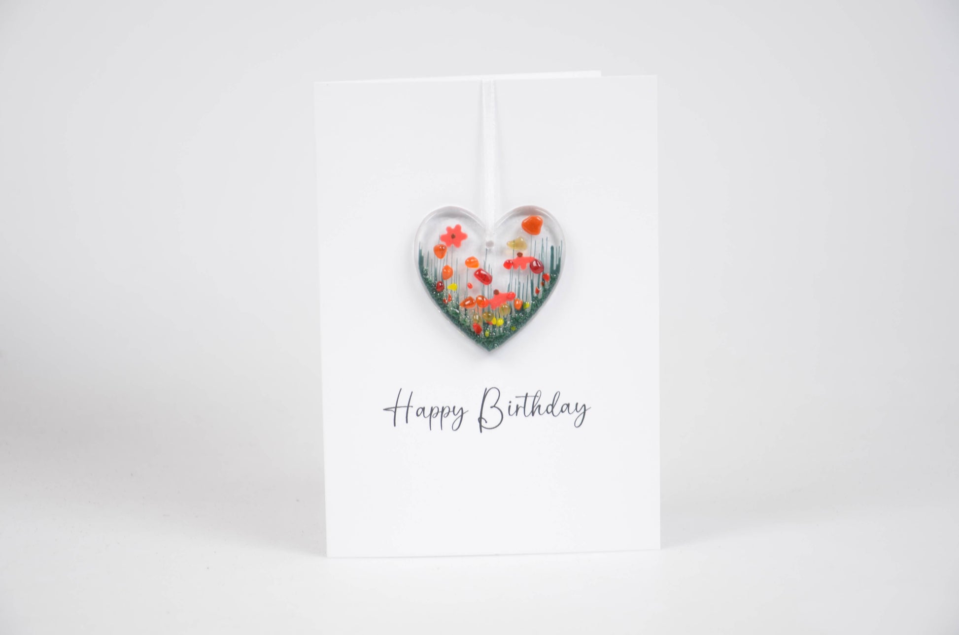 Heart-shaped floral decoration with 'Happy Birthday' text on a white background