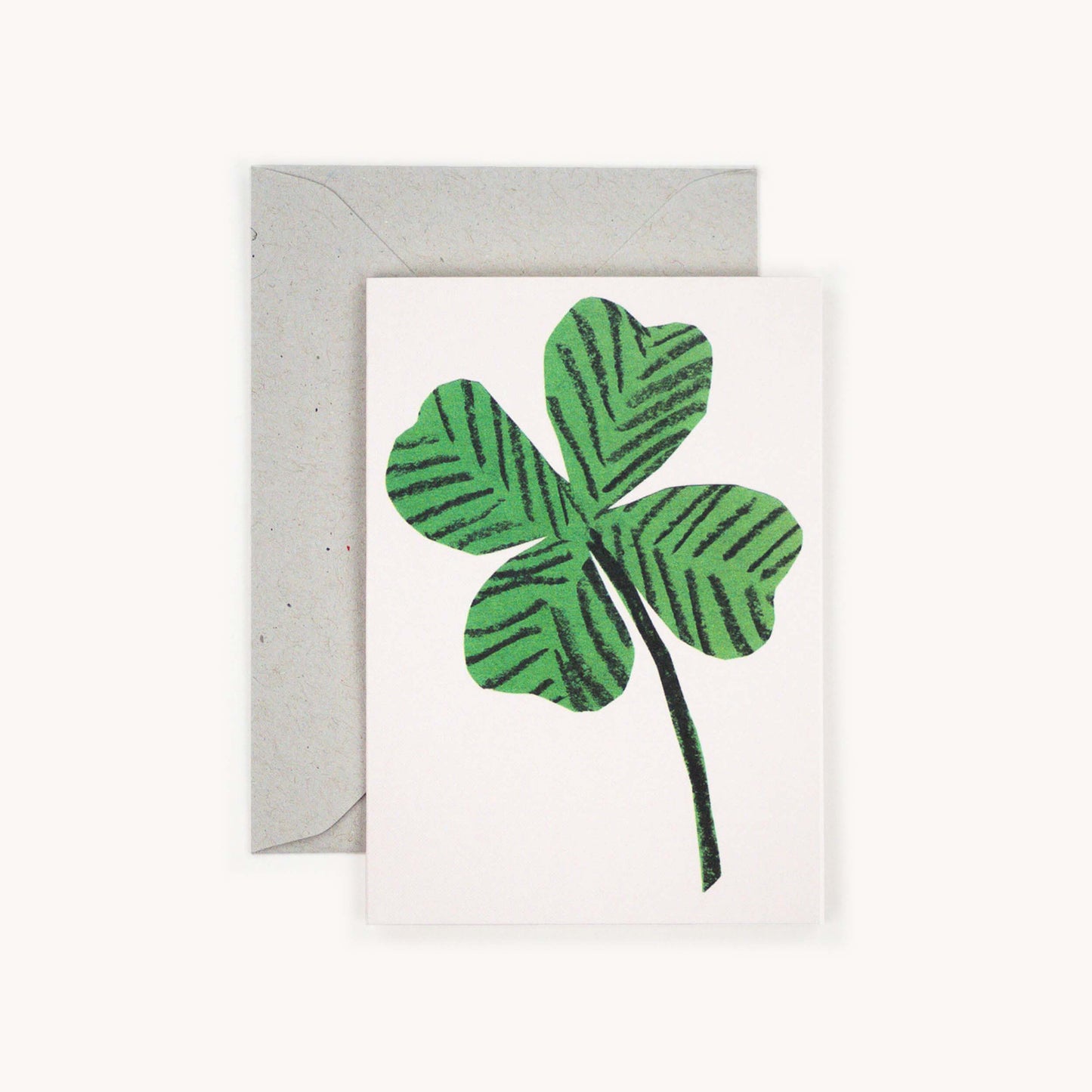 Small greetings card with a 4 leaf clover on a white background.