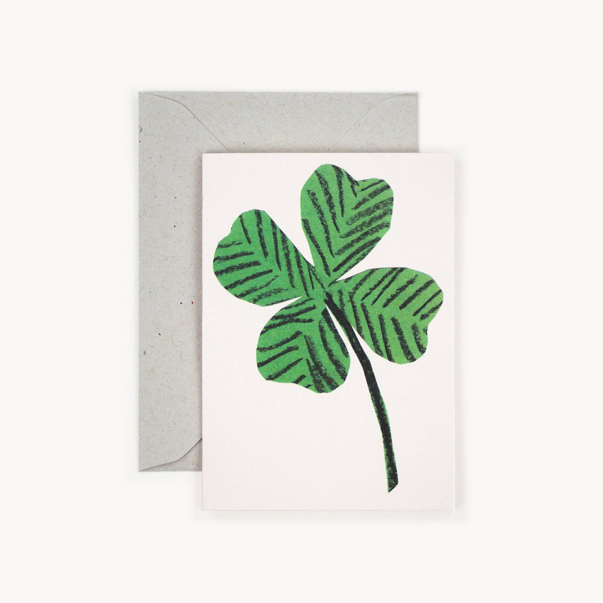Small greetings card with a 4 leaf clover on a white background.
