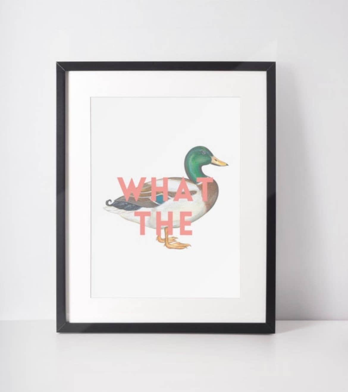 Framed print with a duck illustration and 'WHAT THE' text on a white background
