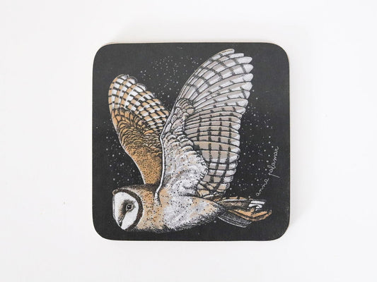 A square black coaster with rounded corners featuring a detailed illustration of a barn owl in flight.