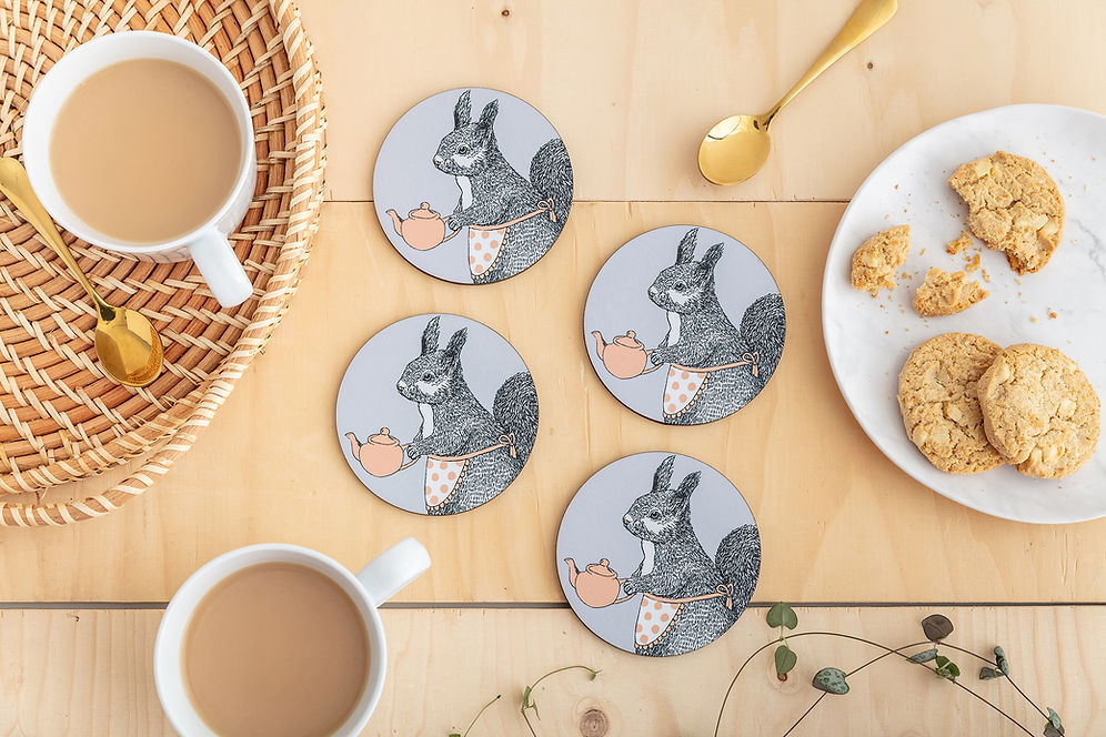 Four round coasters featuring an illustration of a grey squirrel in a little apron holding a pink teapot.