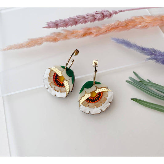 Floral earrings on a white surface with dried lavender and grasses.