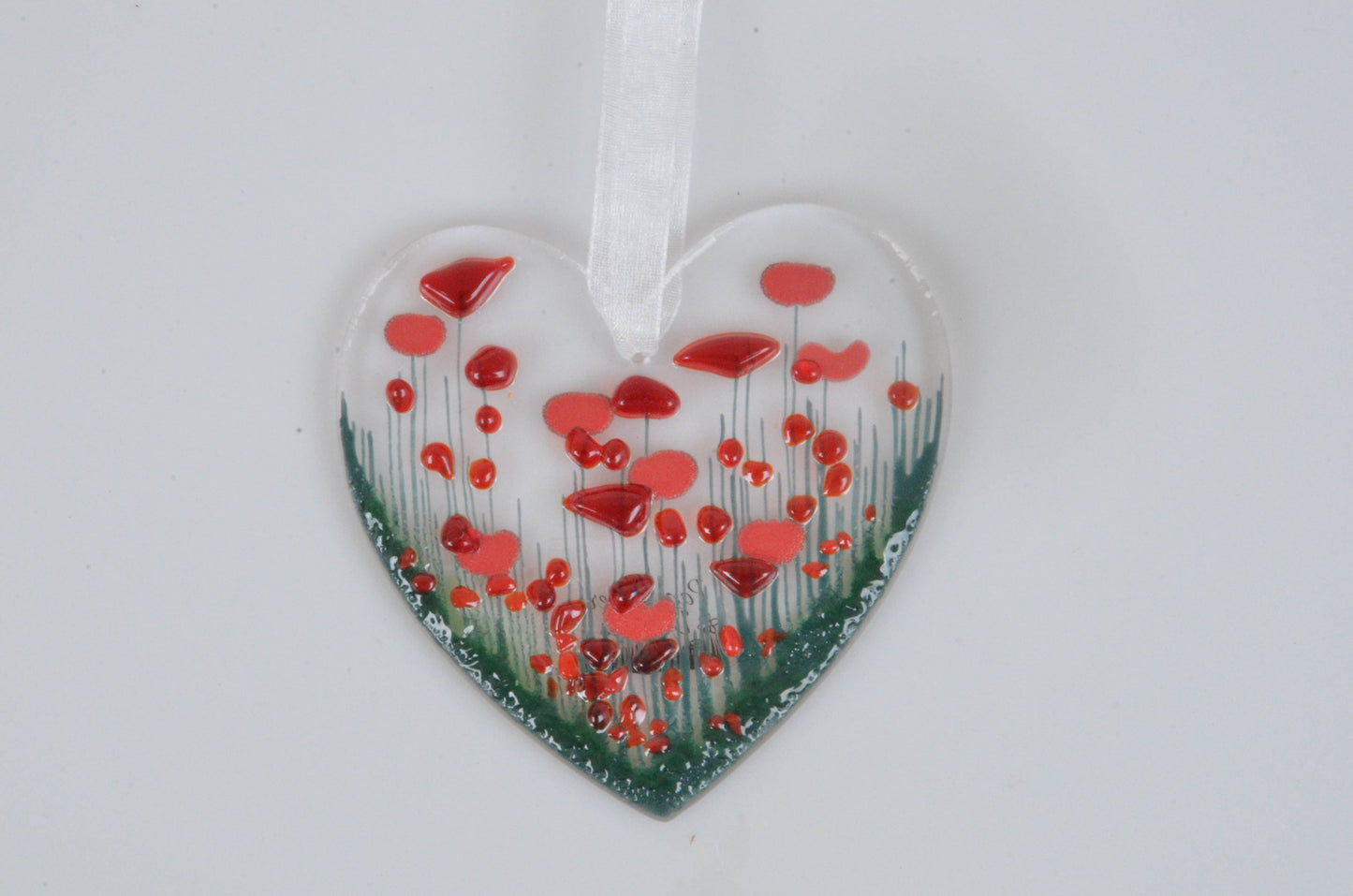 Heart-shaped ornament with red floral design on a white background