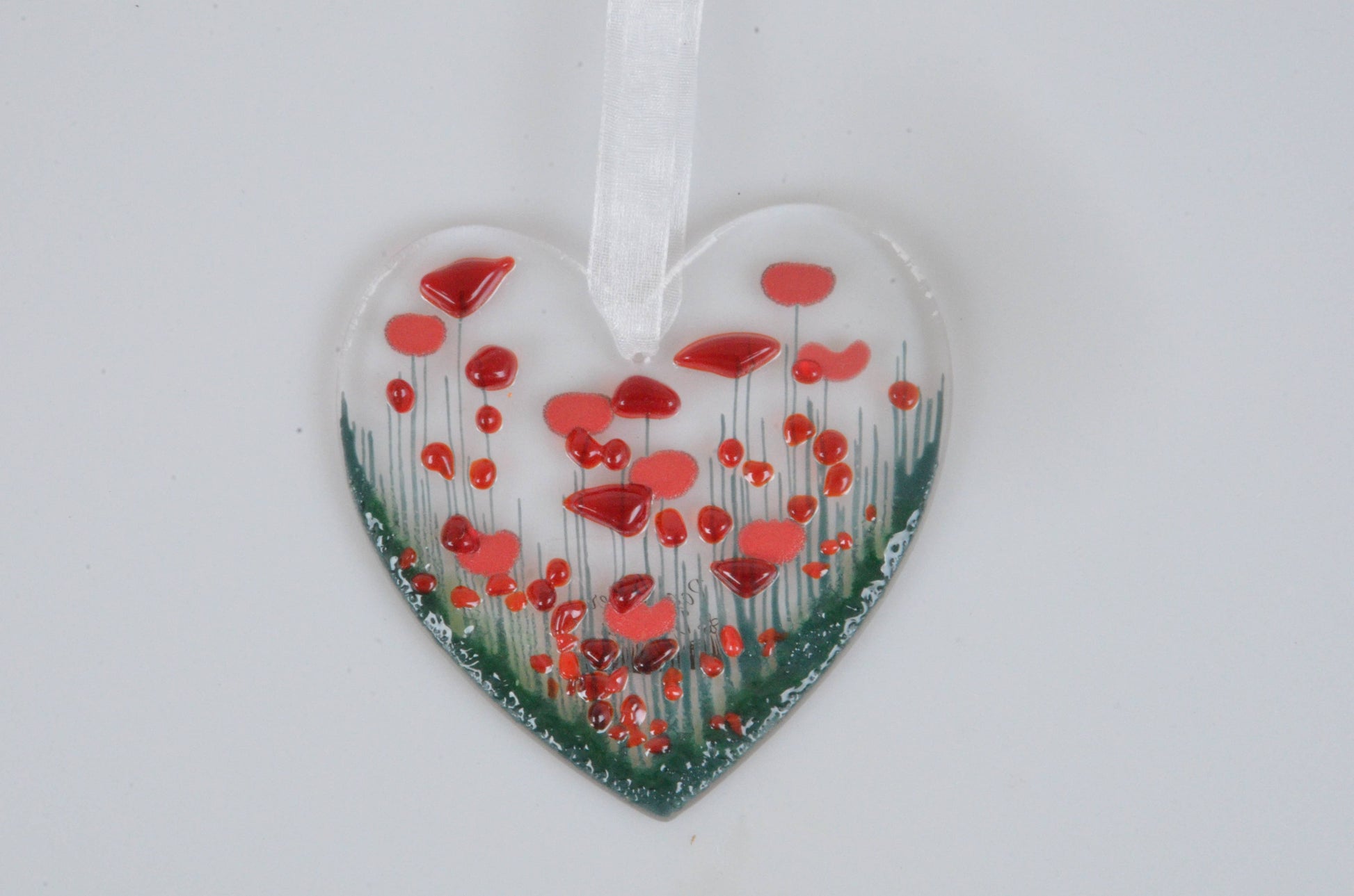 Heart-shaped ornament with red floral design on a white background