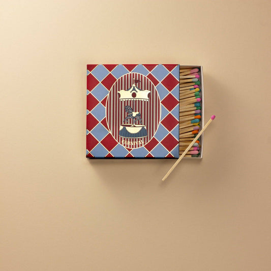 Matchbox with colorful matches on a beige background
