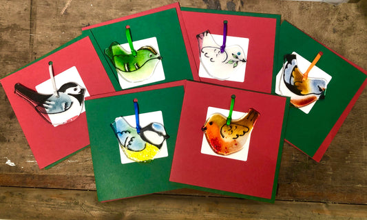 Set of colorful greeting cards with animal illustrations on a wooden surface