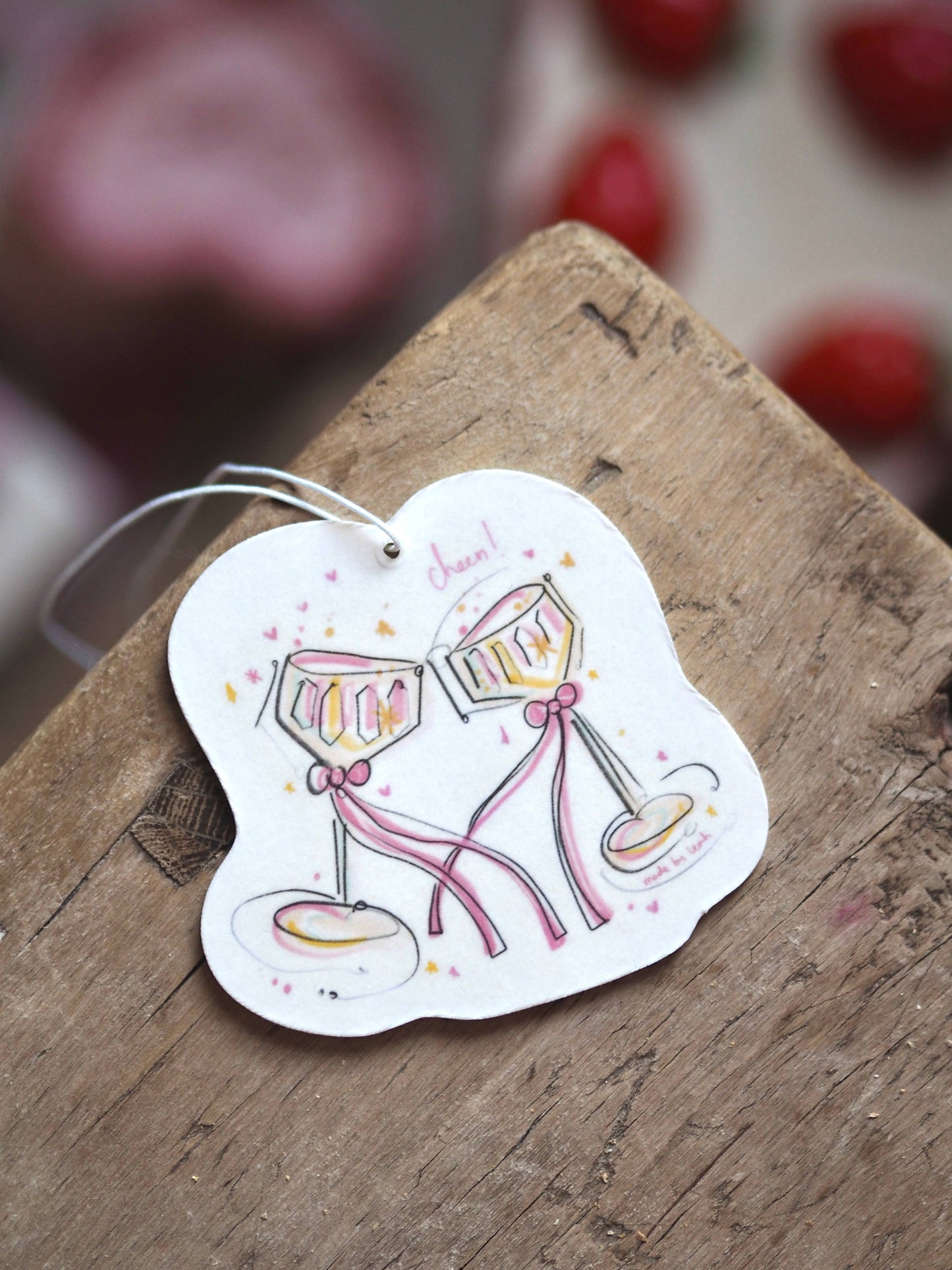 Decorative tag with champagne glasses on a wooden surface