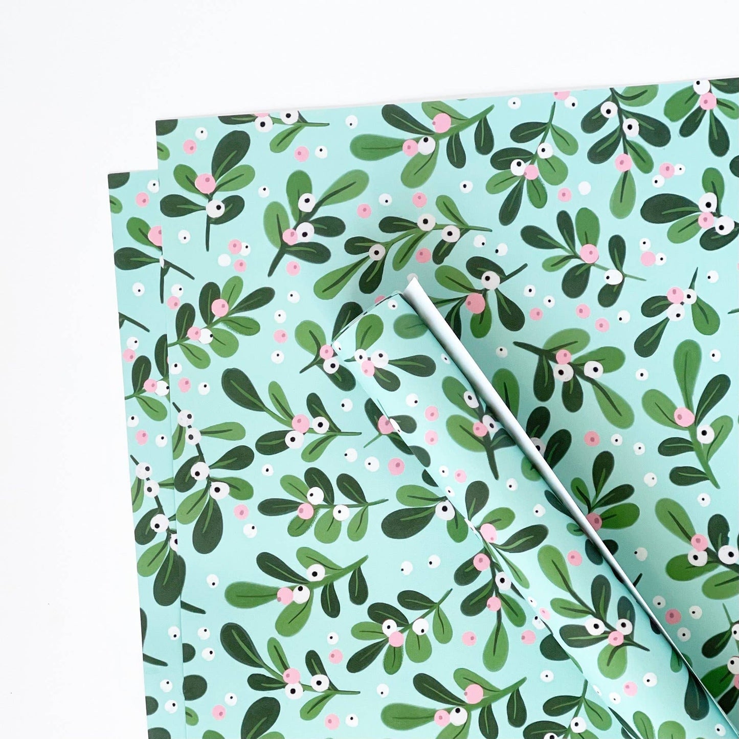 Floral patterned paper with green leaves and pink flowers on a light blue background