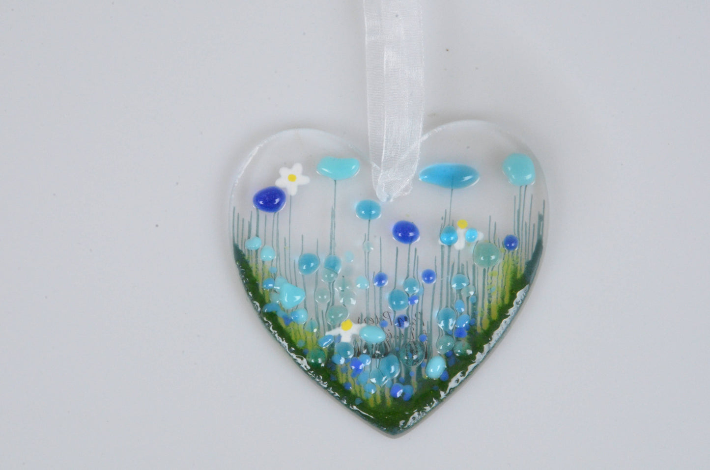 Heart-shaped ornament with blue flowers on a white background