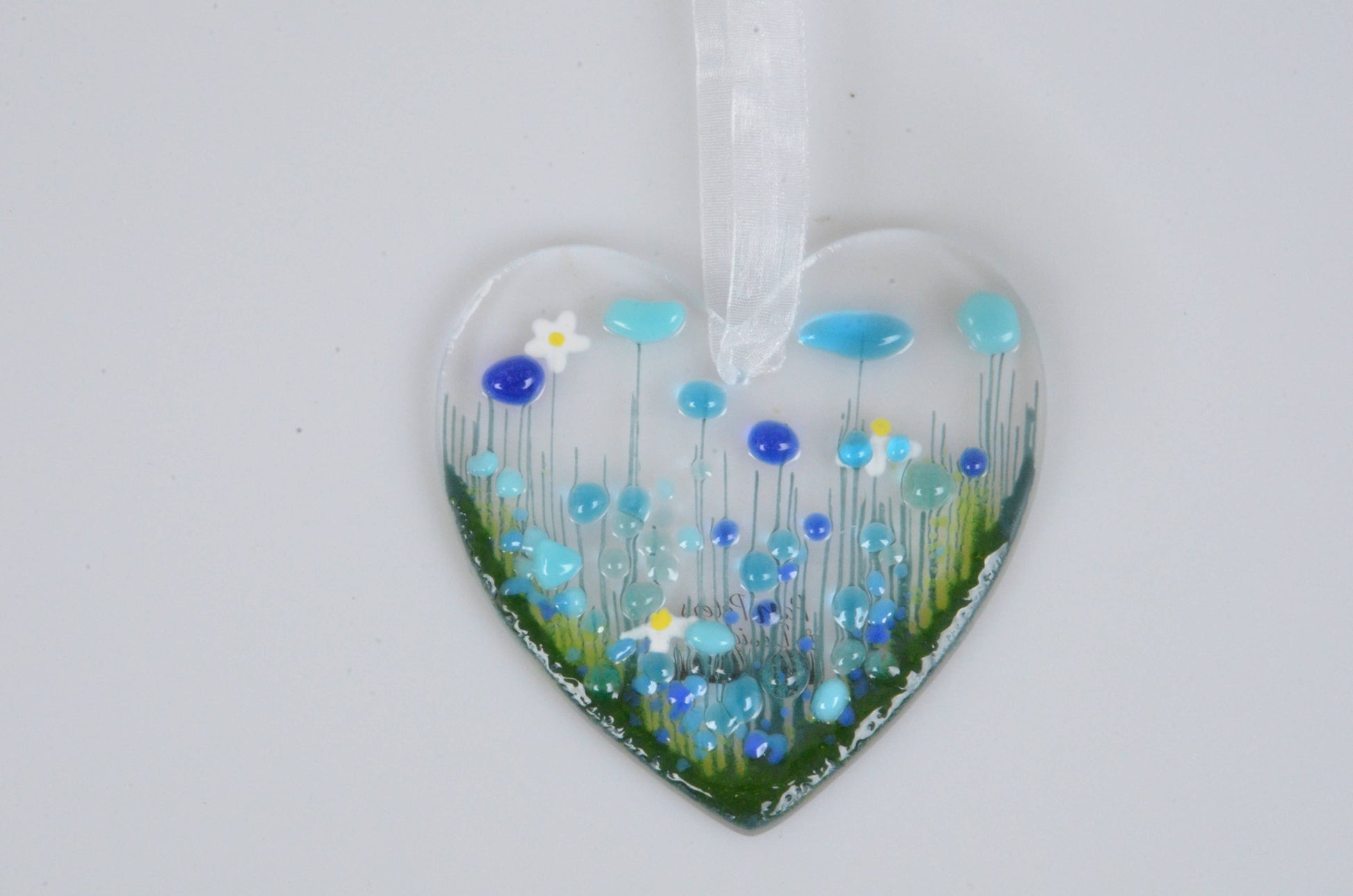 Heart-shaped ornament with blue flowers on a white background