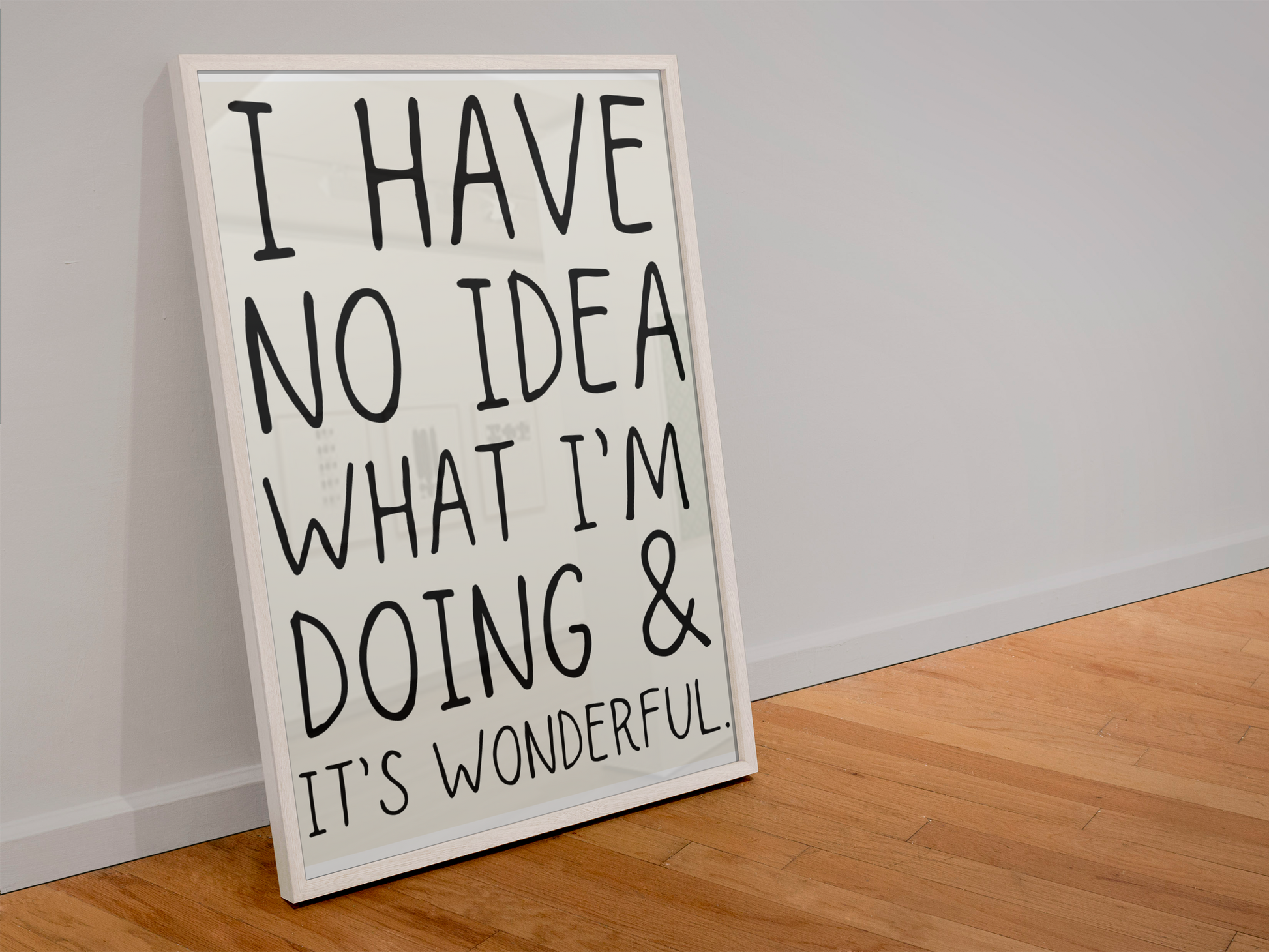 Framed sign with text 'I have no idea what I'm doing & it's wonderful' leaning against a wall.