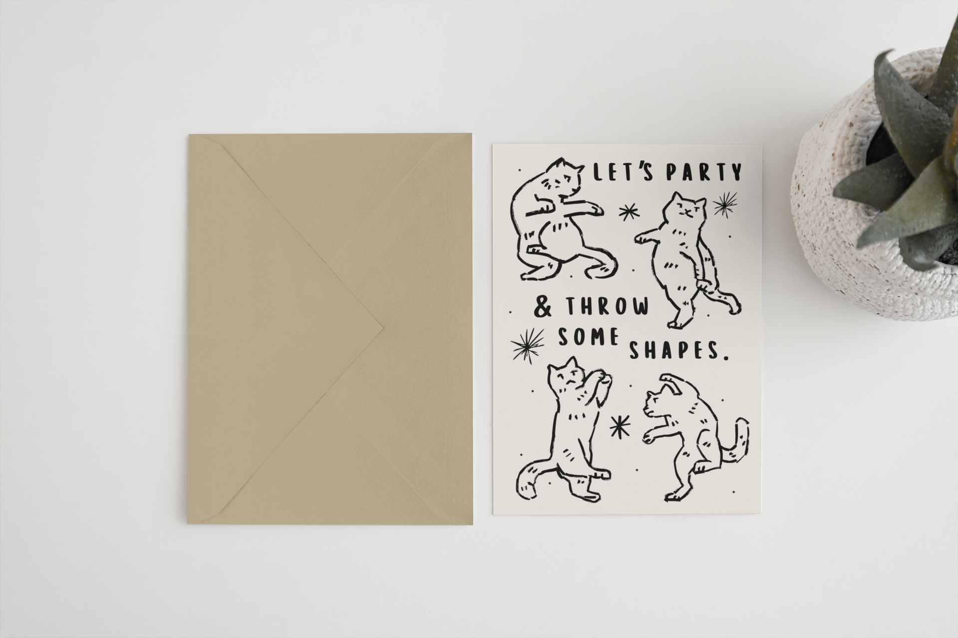 Greeting card with bear illustrations and text 'Let's party & throw some shapes' on a white surface.