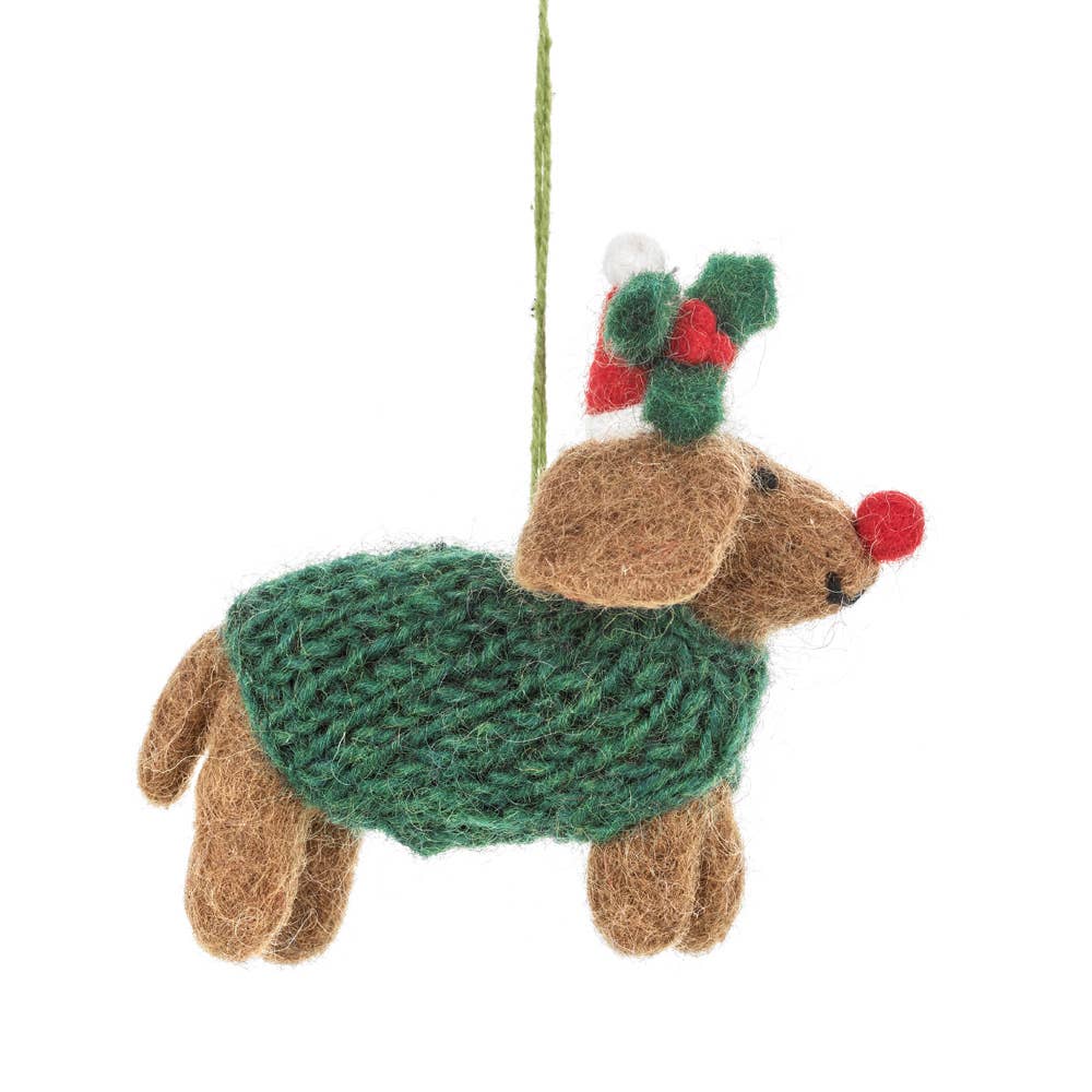 Christmas ornament of a dog wearing a green sweater and Santa hat on a white background